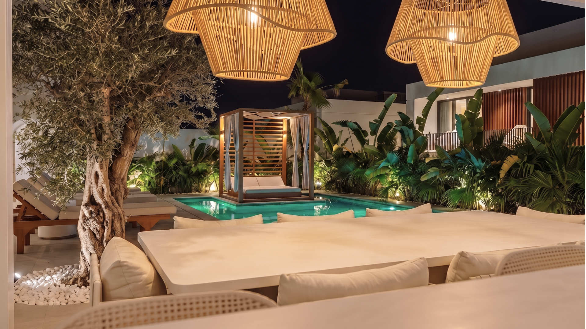 Landscaped pool garden with outdoor lounge, timber cabana and woven pendant lights at night.