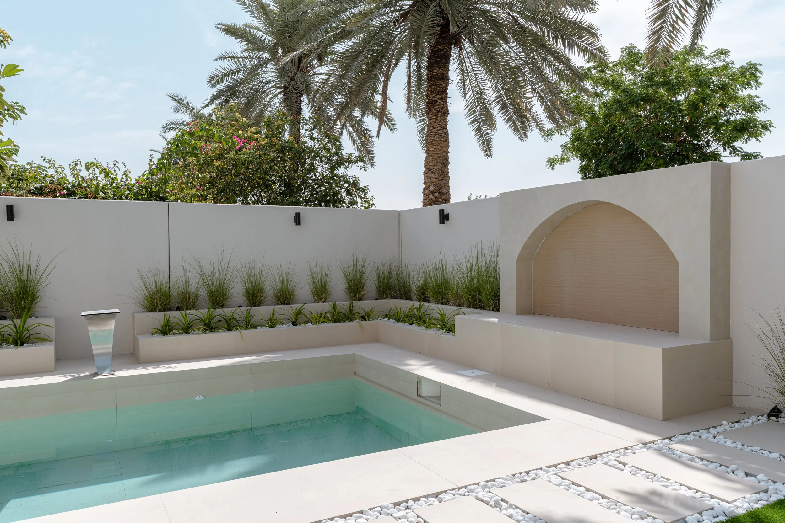 Al Reem 1 Arabian Ranches villa pool with outdoor shower, landscaped planting and stepping-stone pathway.