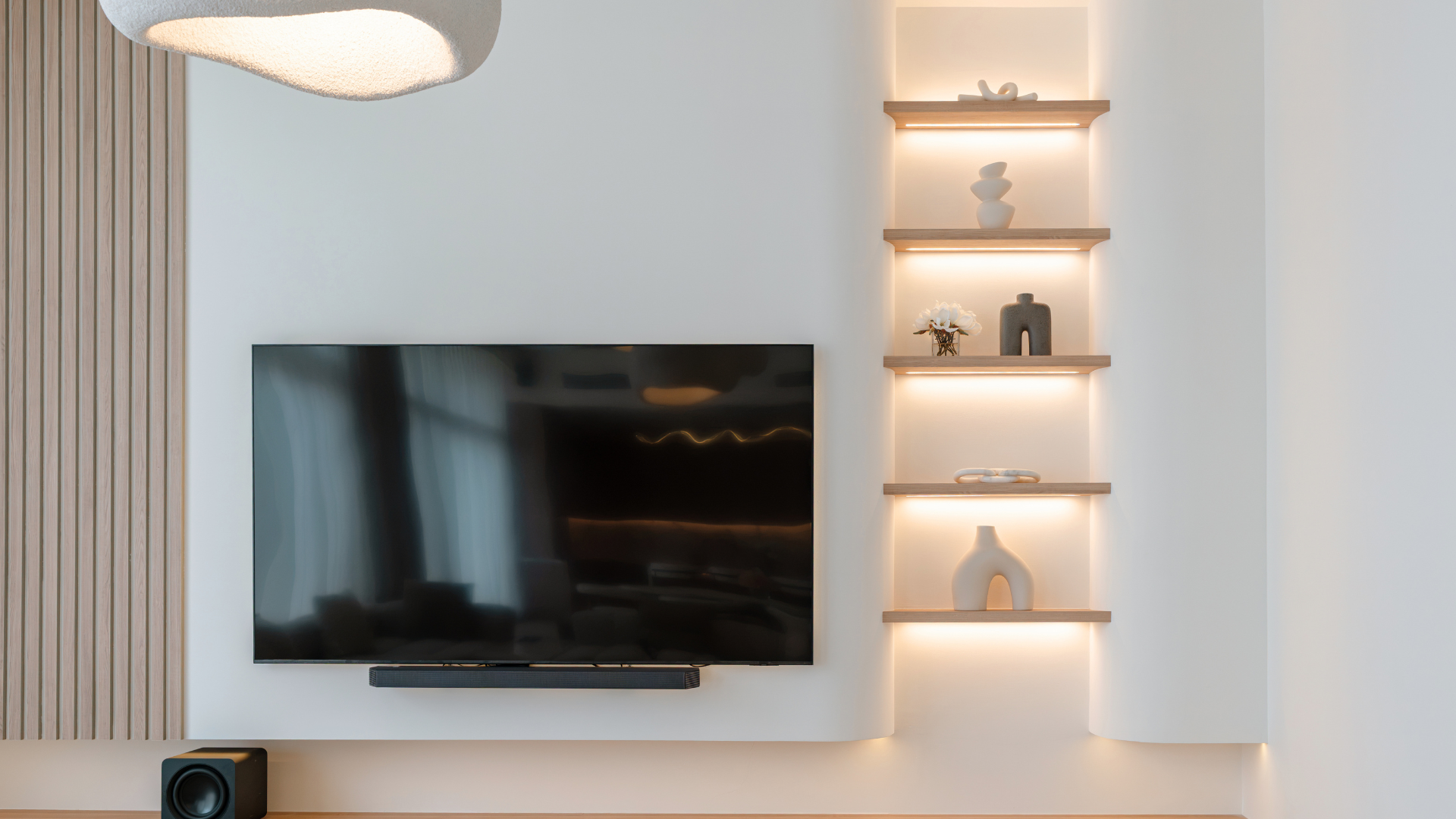Bespoke television wall with illuminated display shelving in a renovated Tilal Al Furjan villa.
