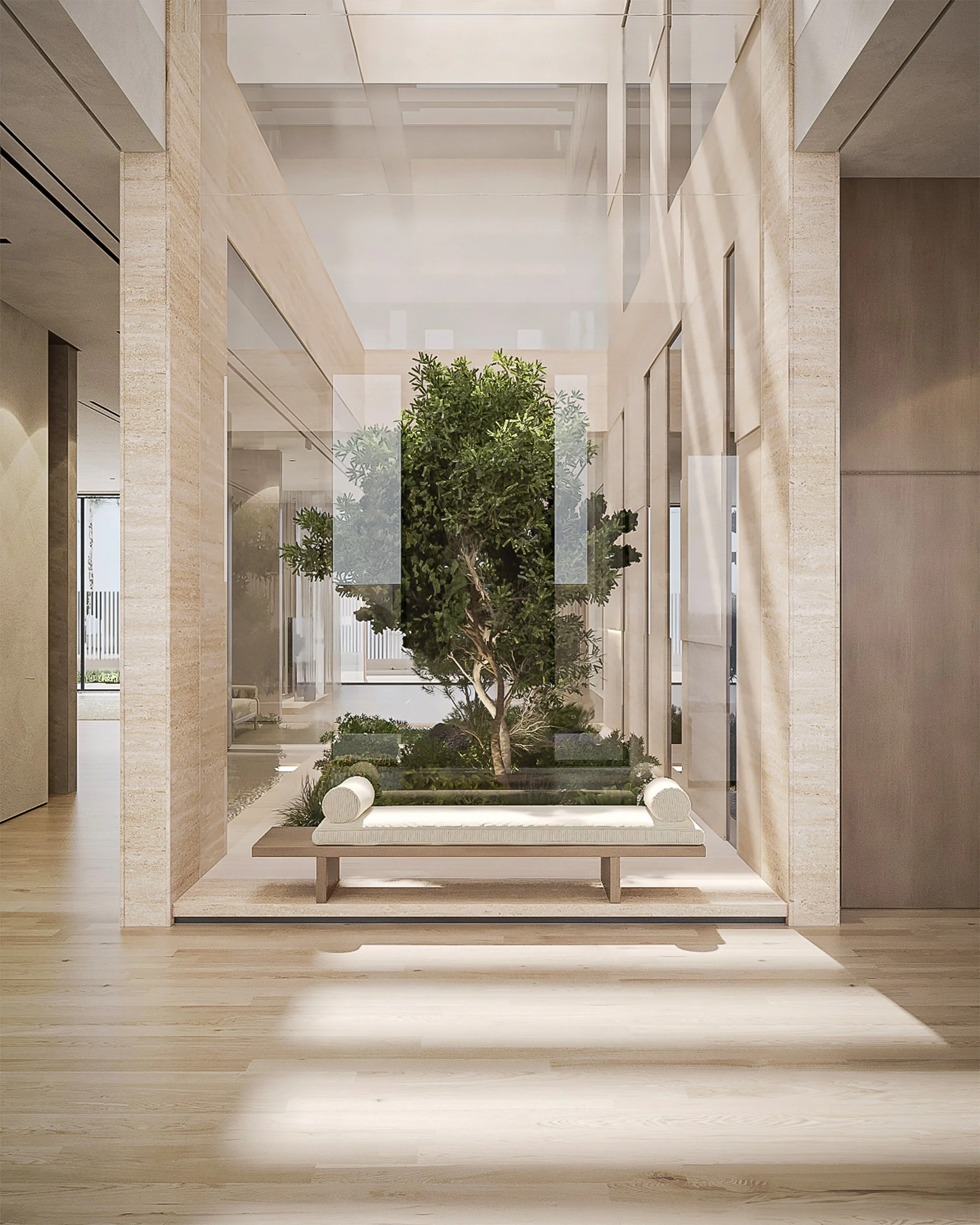 Al Barari villa courtyard with indoor tree, stone columns, glass panels and built-in bench seating.