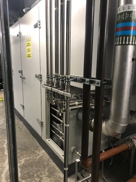 Industrial HVAC or refrigeration unit with pipes and control panels.