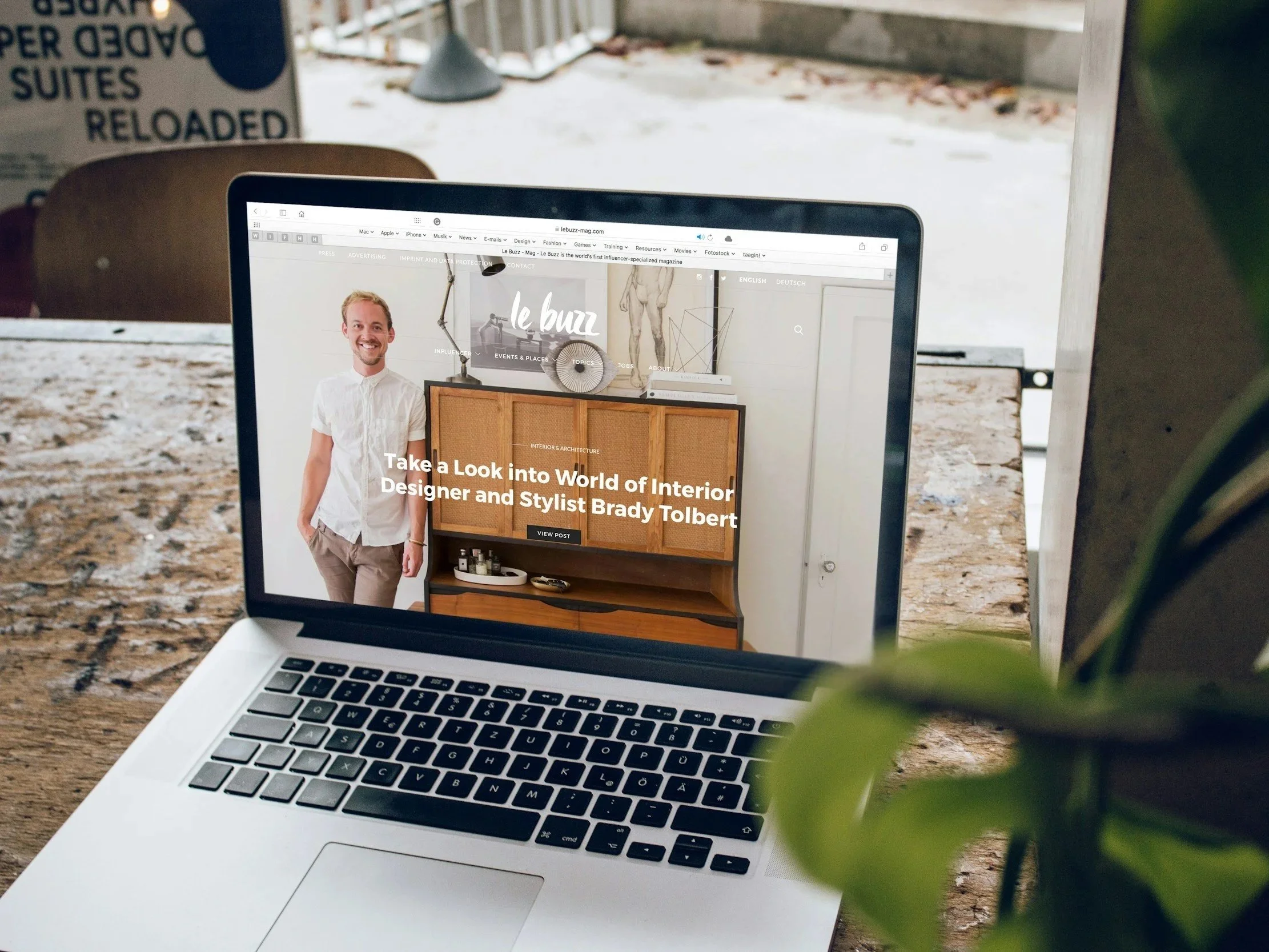 Open MacBook displaying a webpage about interior designer Brady Tolbert, showing a man in a white shirt standing next to furniture in a bright room. Displaying Polaar Media's website creation capabilities.
