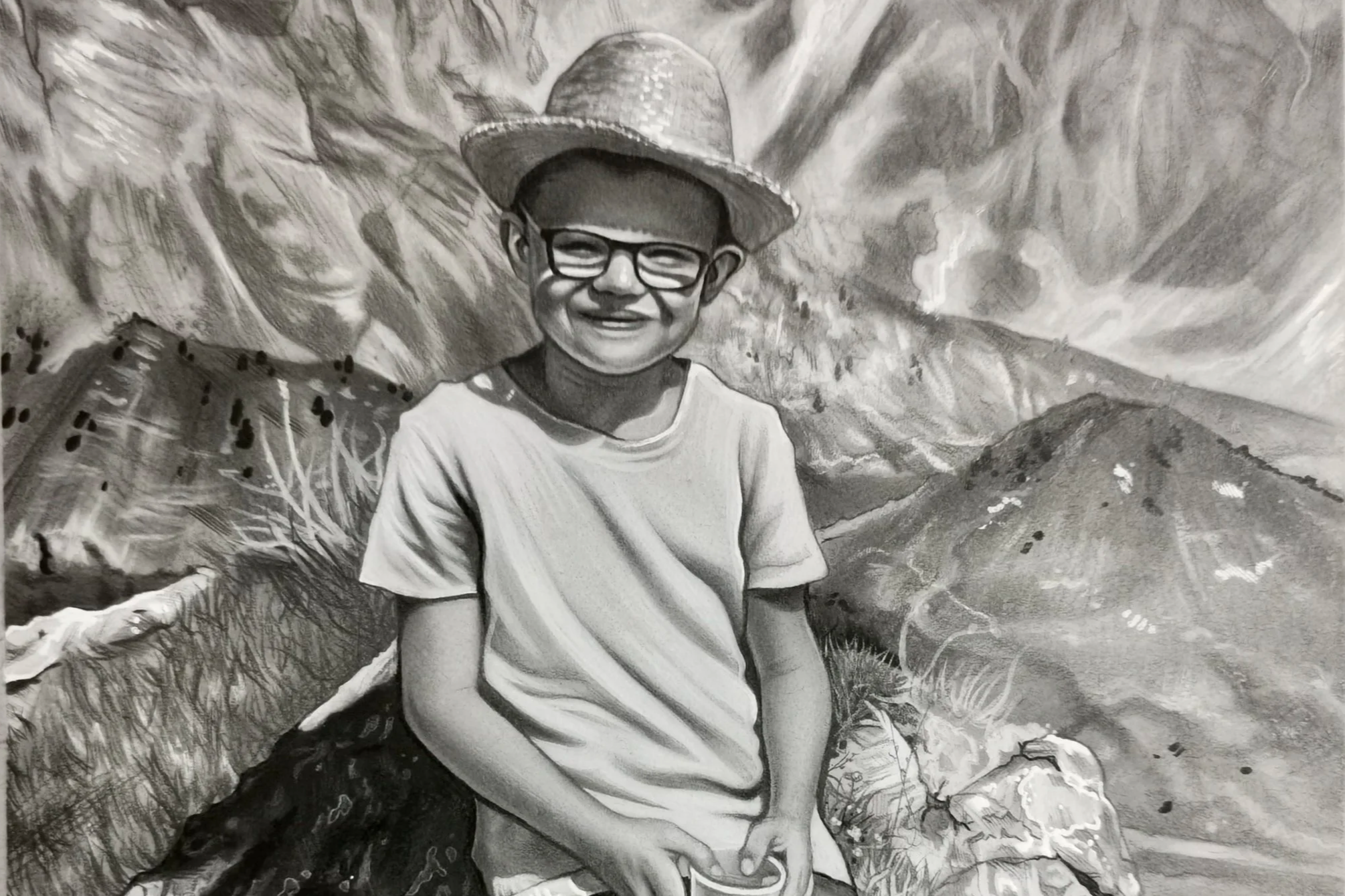 Schwarz-weiß Wandbild eines lachenden Jungen mit Brille und Strohhut vor Bergen und Landschaft.