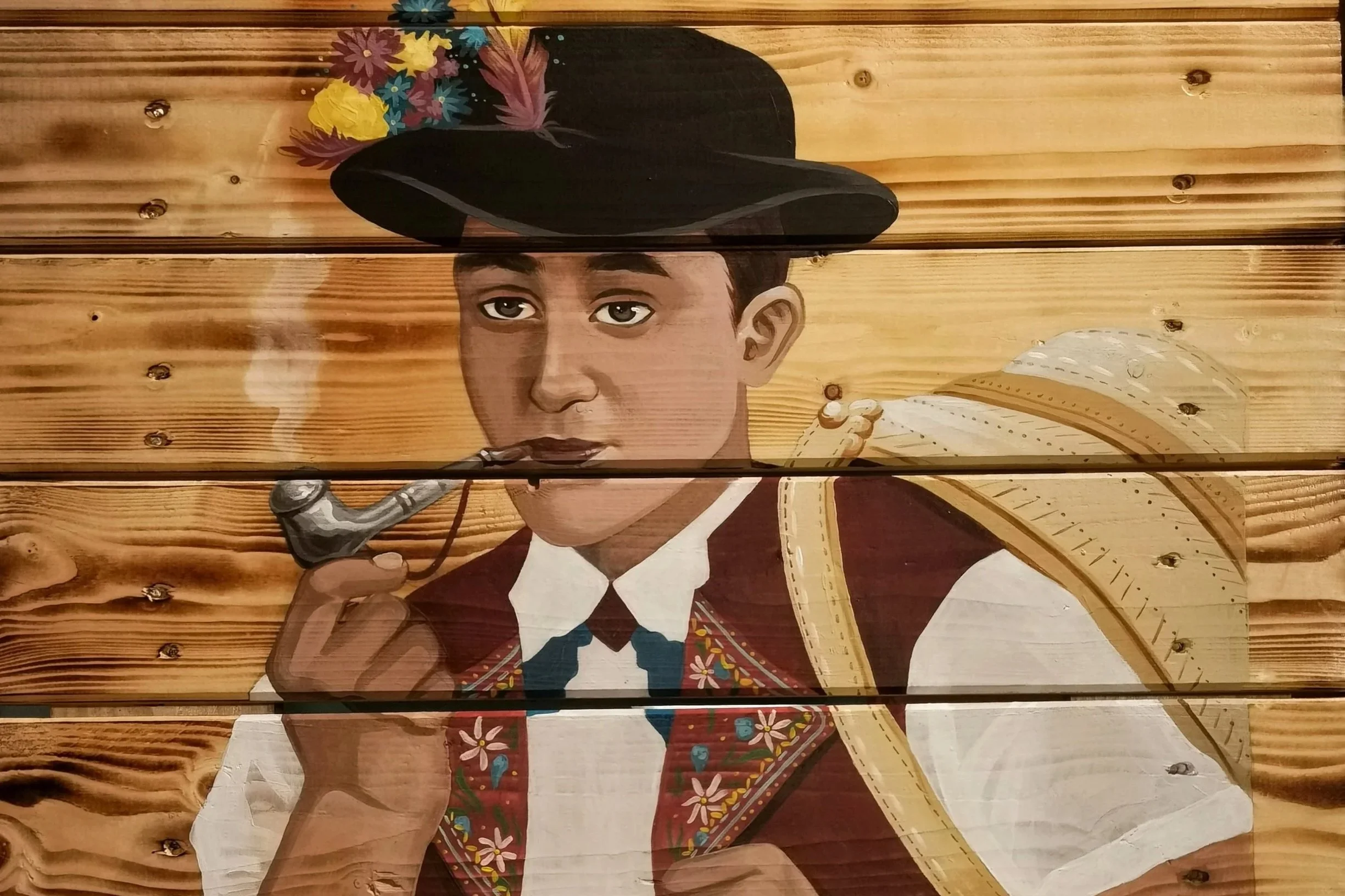 Gemaltes Porträt eines jungen Mannes mit Zigarre, Trenchcoat, Hut mit Blumen und Rucksack, auf Holzwand