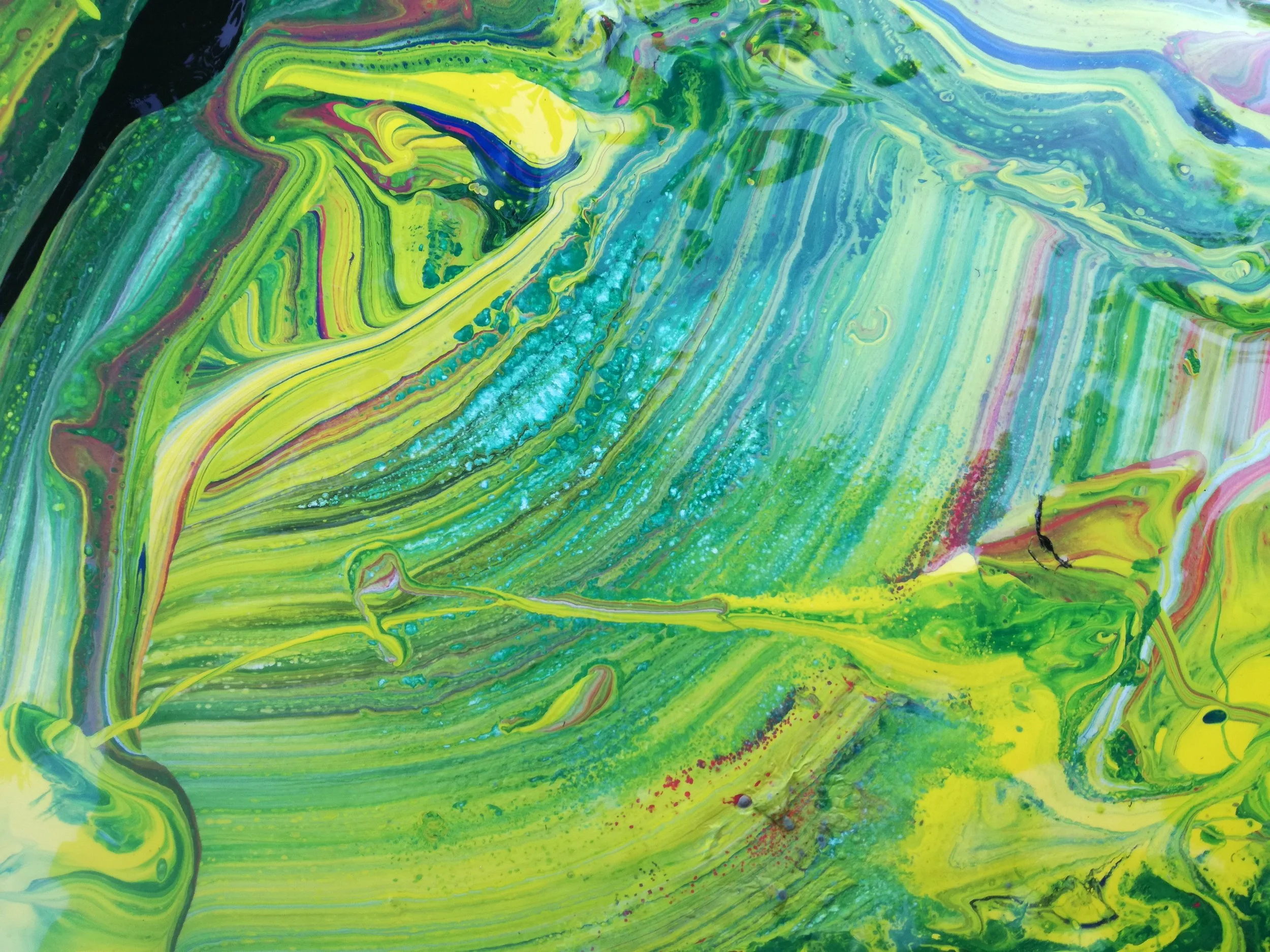 Abstract fluid art painting in shades of green, yellow, blue, and hints of pink and purple with swirling patterns and splatters.