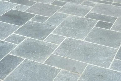 Close-up of gray stone tiles arranged in a pattern on a pavement or floor.