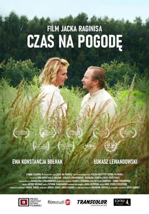 A poster for a film titled "Czas na Pogodę" featuring a man and a woman standing in a field of tall grass, looking at each other with a background of trees and a blue sky.