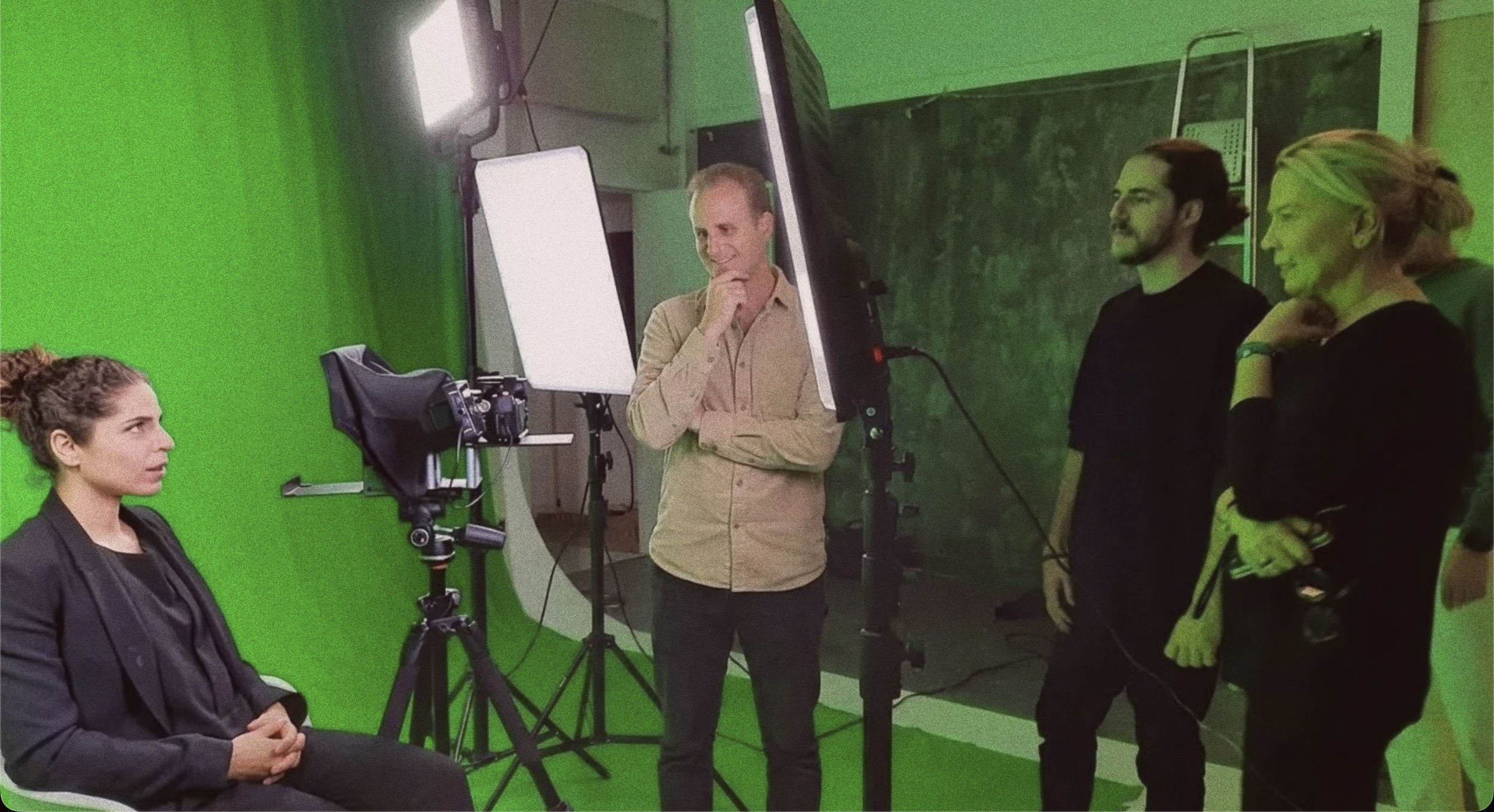 Trois personnes regardent une scène se tourner devant un fond vert