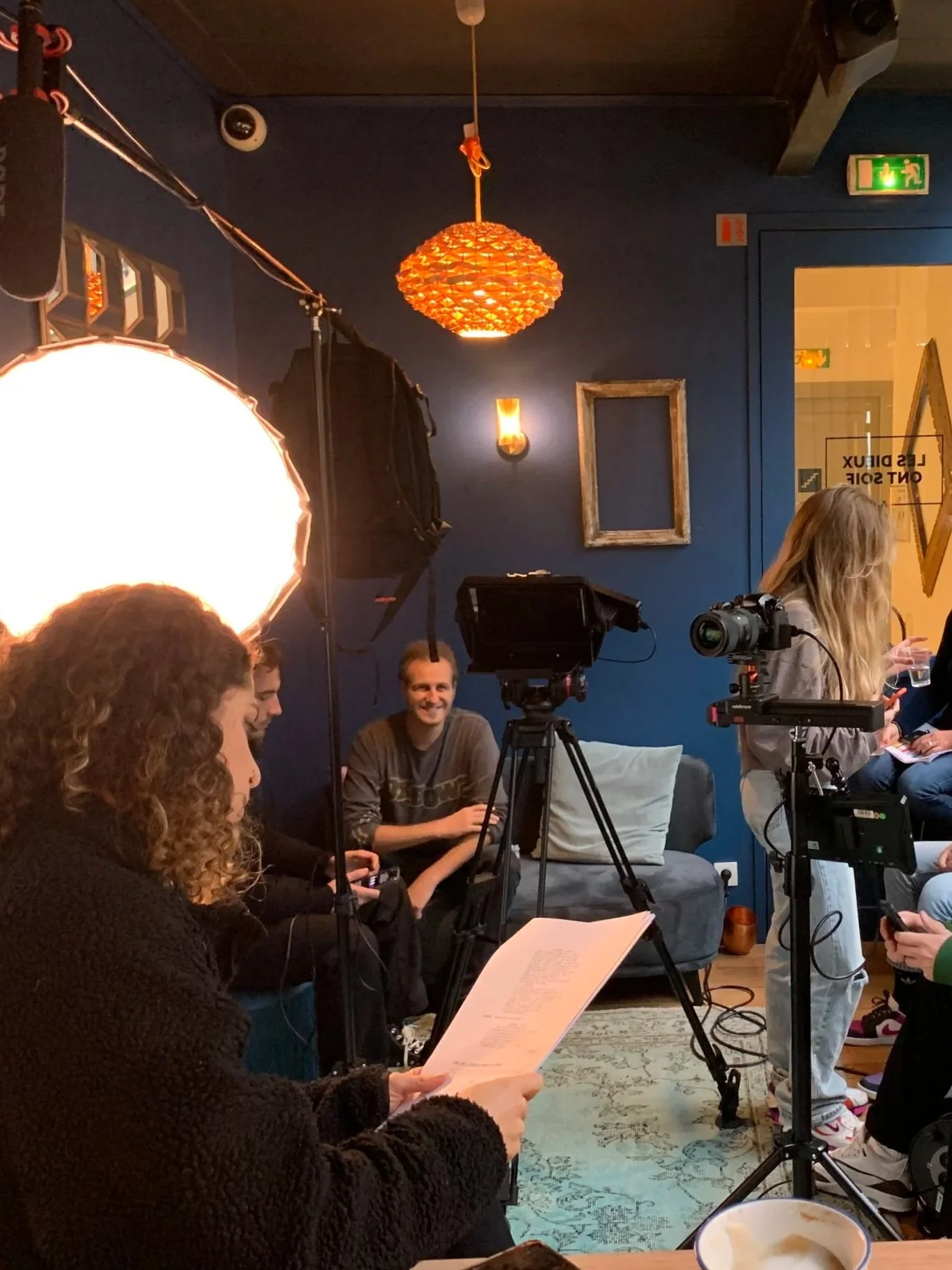 Une équipe de tournage se prépare à filmer, une comédienne lit son script, pendant que le reste de l'équipe installent les caméras et les lumières