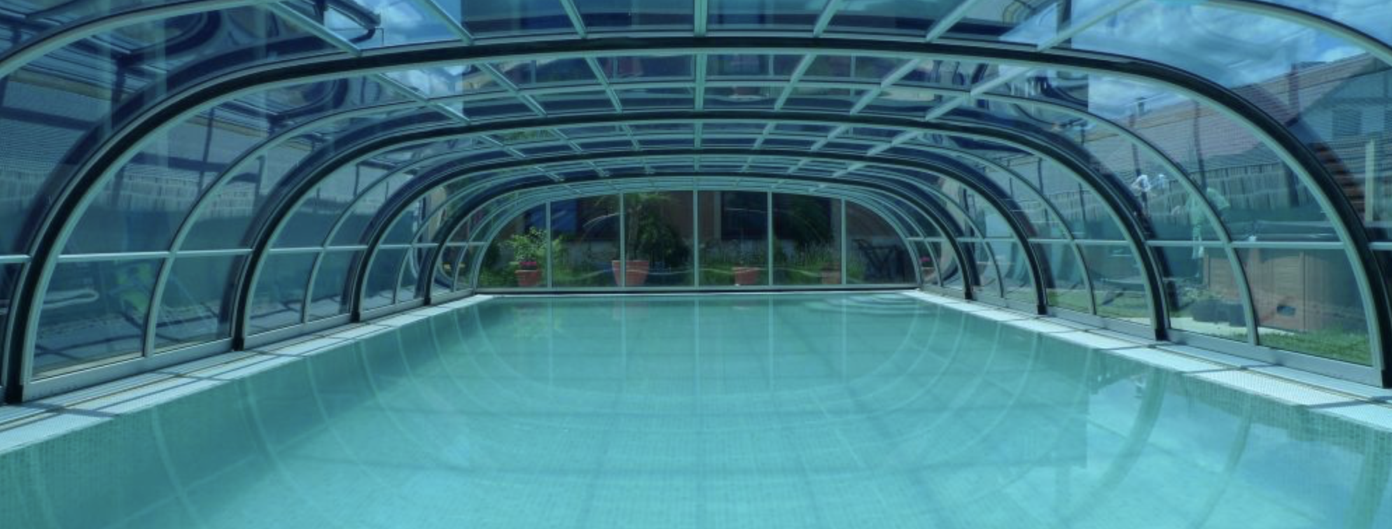 NEPTUNE középmagas íves medencefedés telepítése modern családi ház kertjébe.