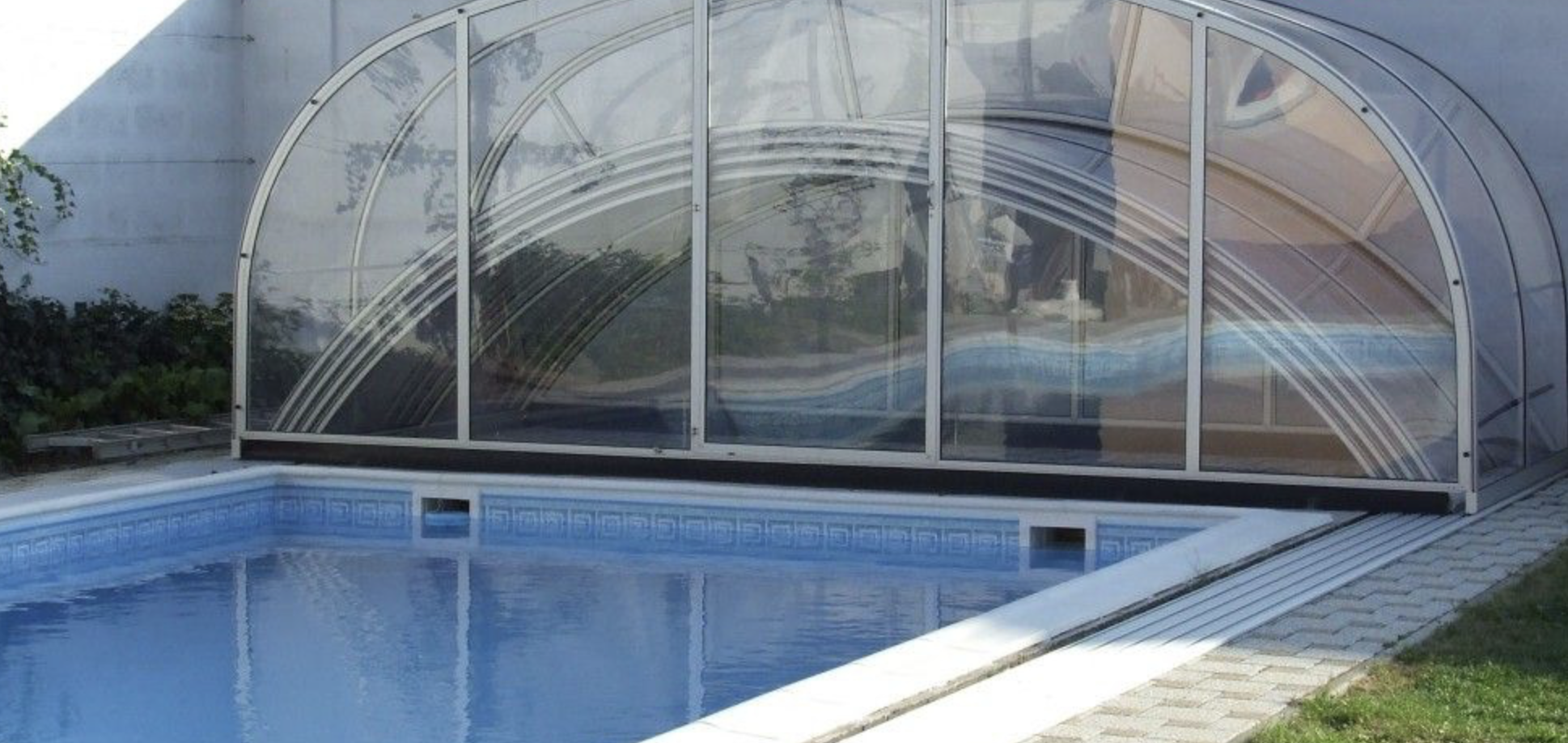 CLASSIC PLUS alacsony profilú íves medencefedés modern kertben.