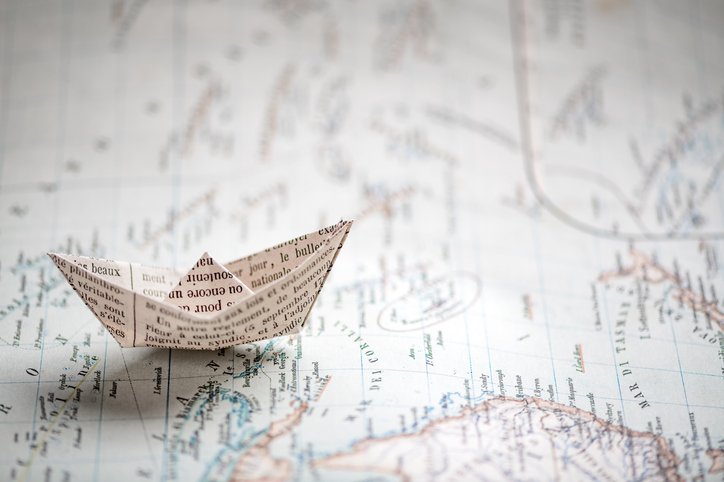 Map image with a boat made of paper on it