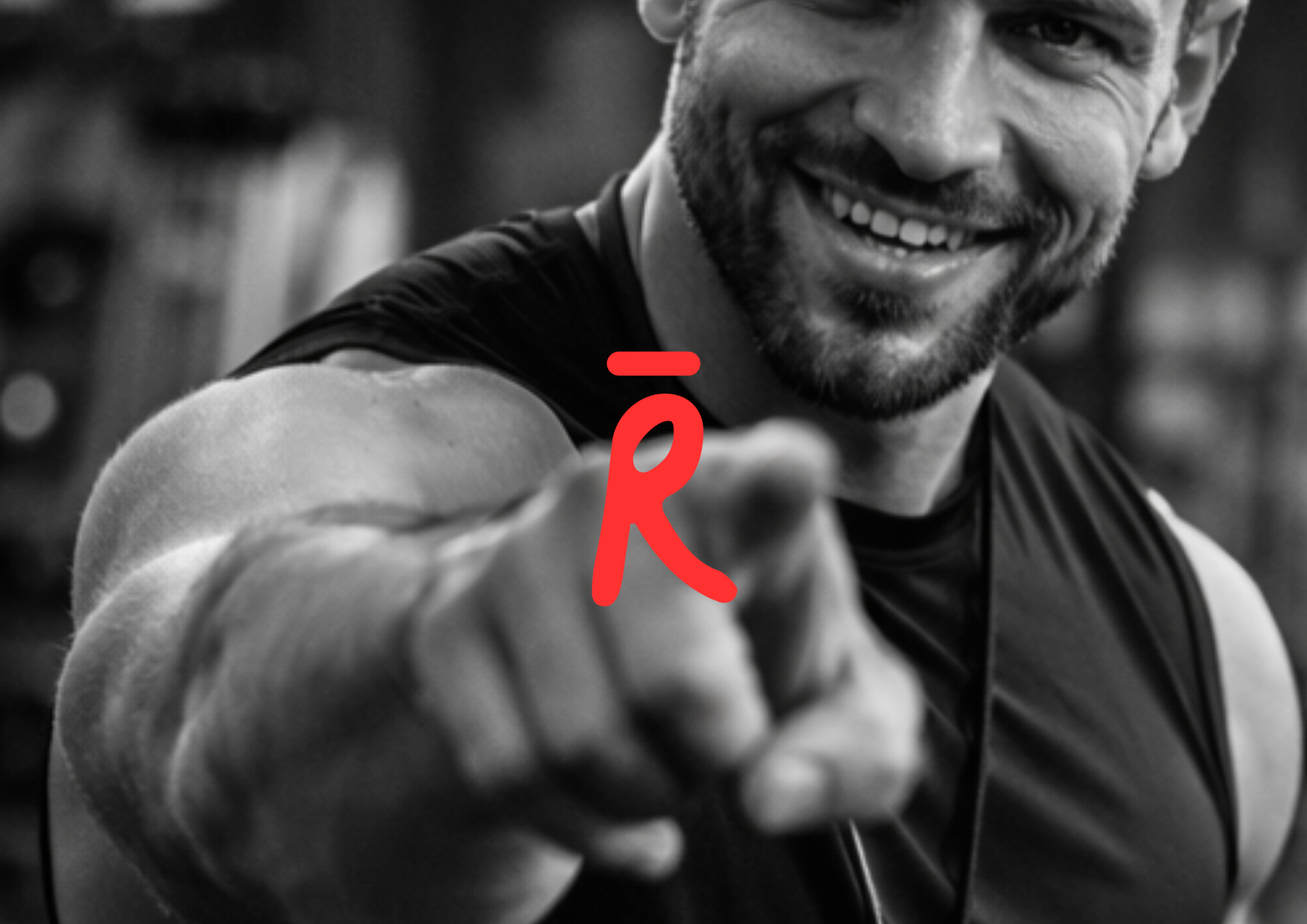 A smiling man in athletic clothing points towards the camera in a gym setting.
