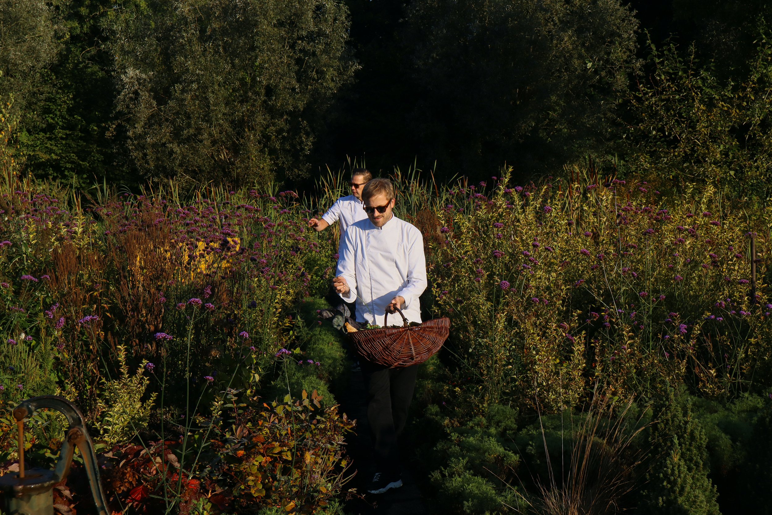 Chefs Henrice Dijks and Jarno Lucas are walking through a garden looking for seasonal products.