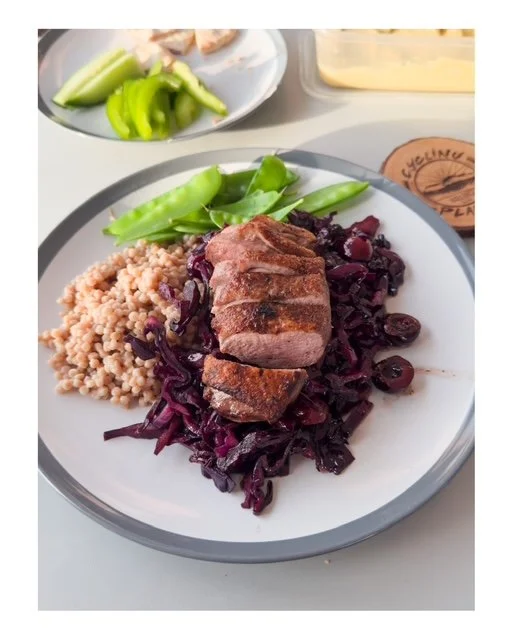 Plate with grilled steak, purple cabbage, couscous, and green snap peas, with celery and cheese in the background.