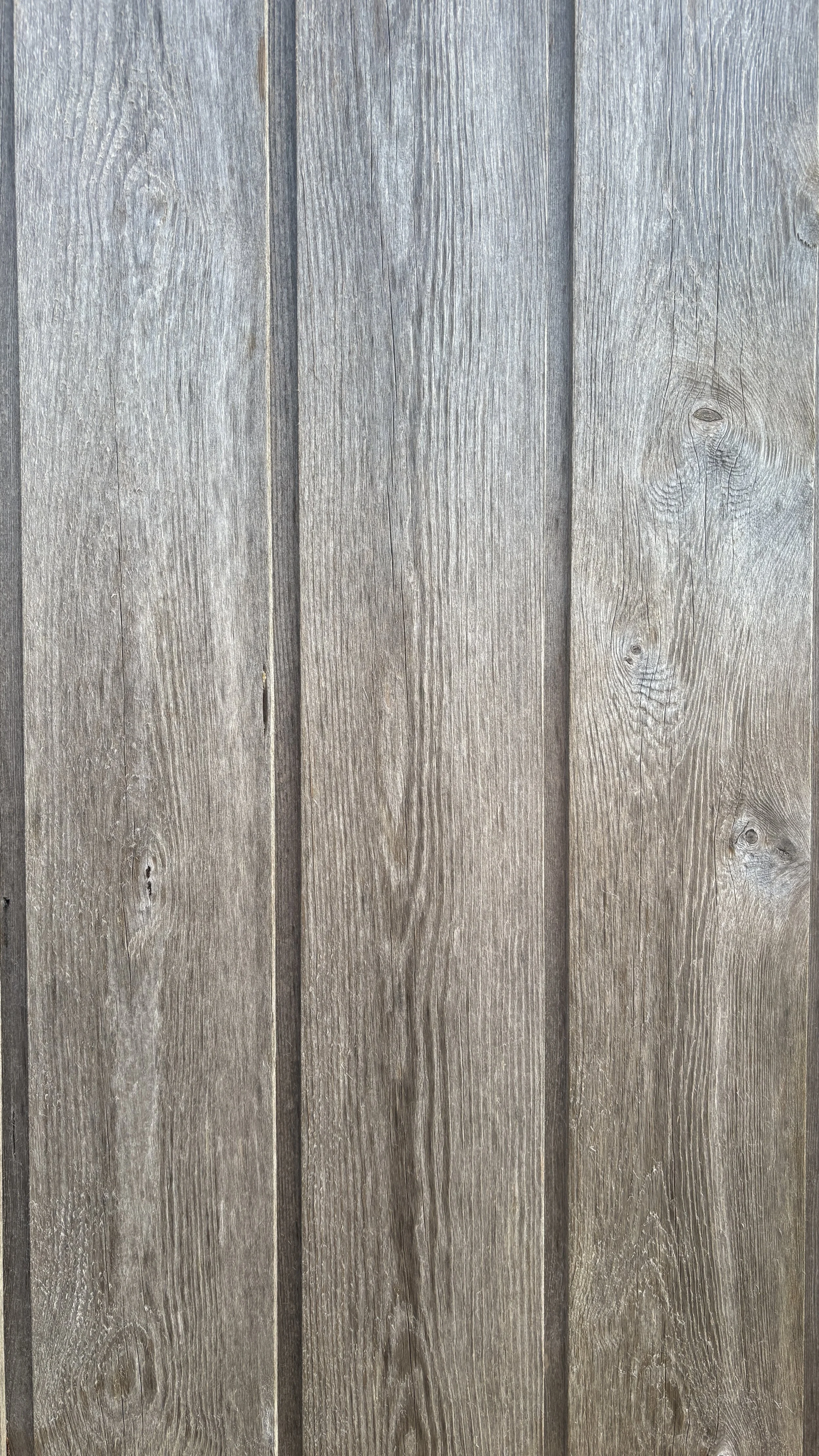 Close-up of weathered gray wooden planks with visible wood grain and knots.