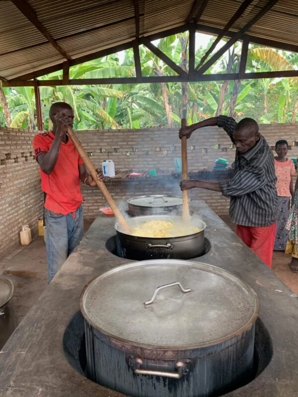 Two men preparing a meal for their community.