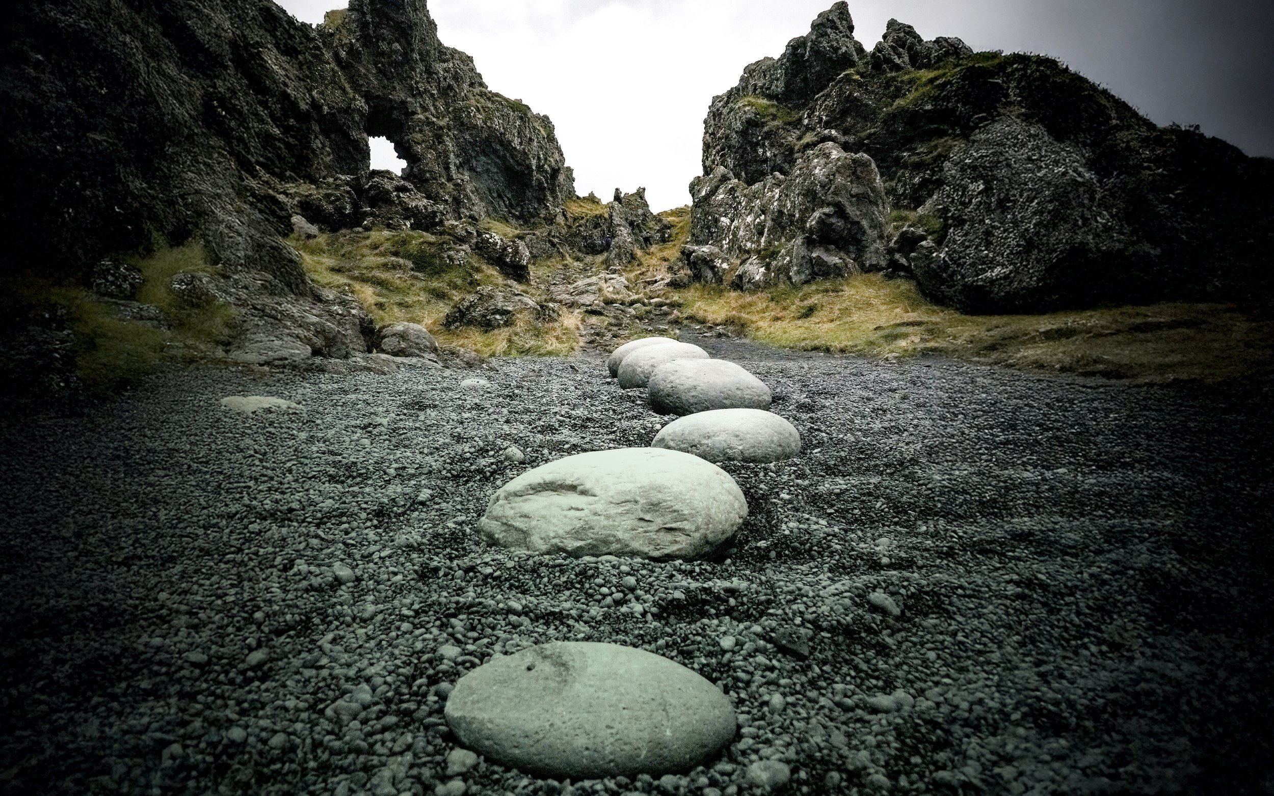 Steinar mynda leið í gegnum grýtt landslag sem tákn fyrir vegferð og þróun – sálfræðiráðgjöf og fræðsla fyrir fyrirtæki og íþróttafélög hjá Sálfræðiklíníkinni.