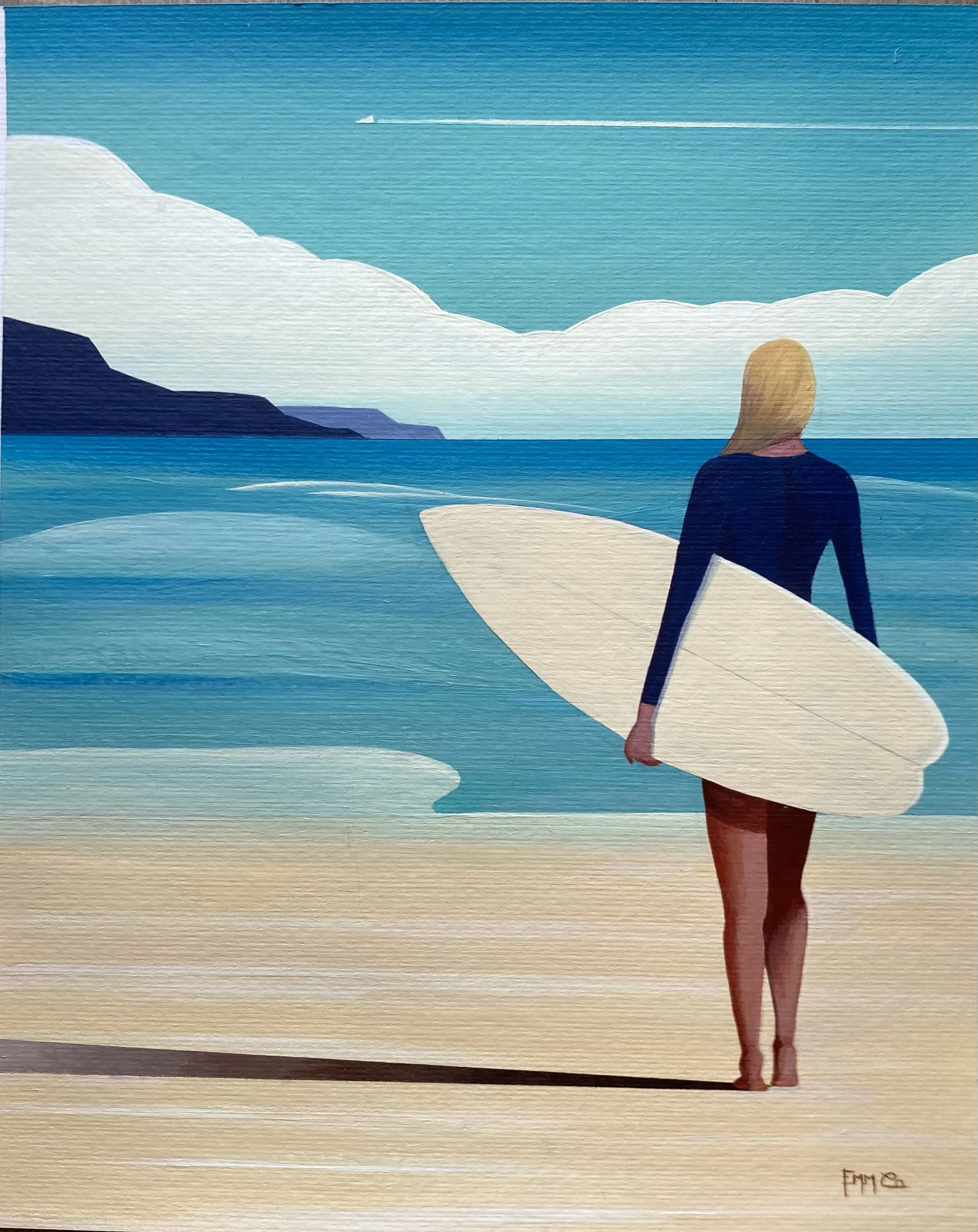 Une femme marche sur la plage avec une planche de surf sous le bras, face à la mer avec des montagnes au loin et un ciel partiellement nuageux.