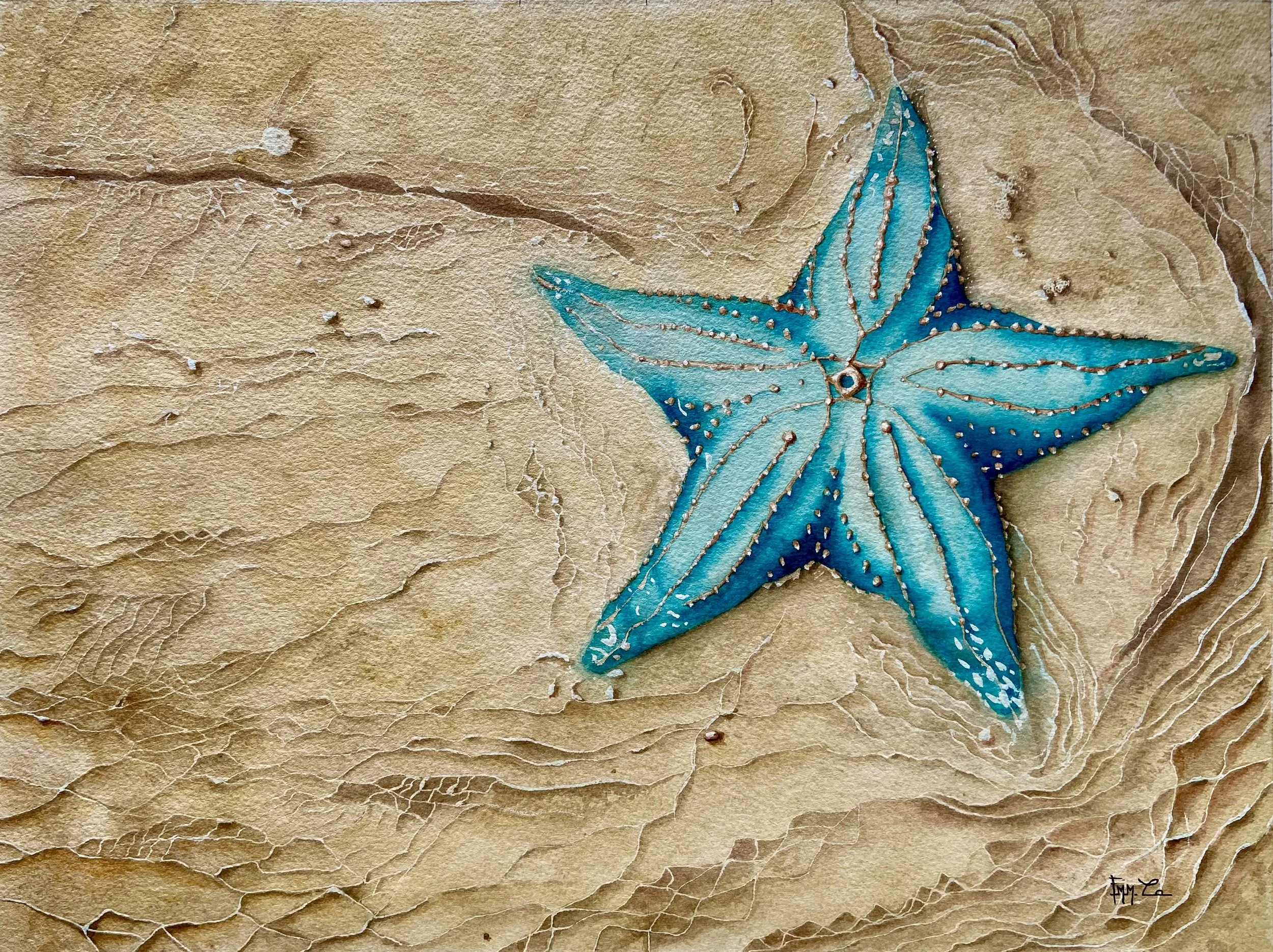 Étoile de mer bleue posée sur du sable beige.
