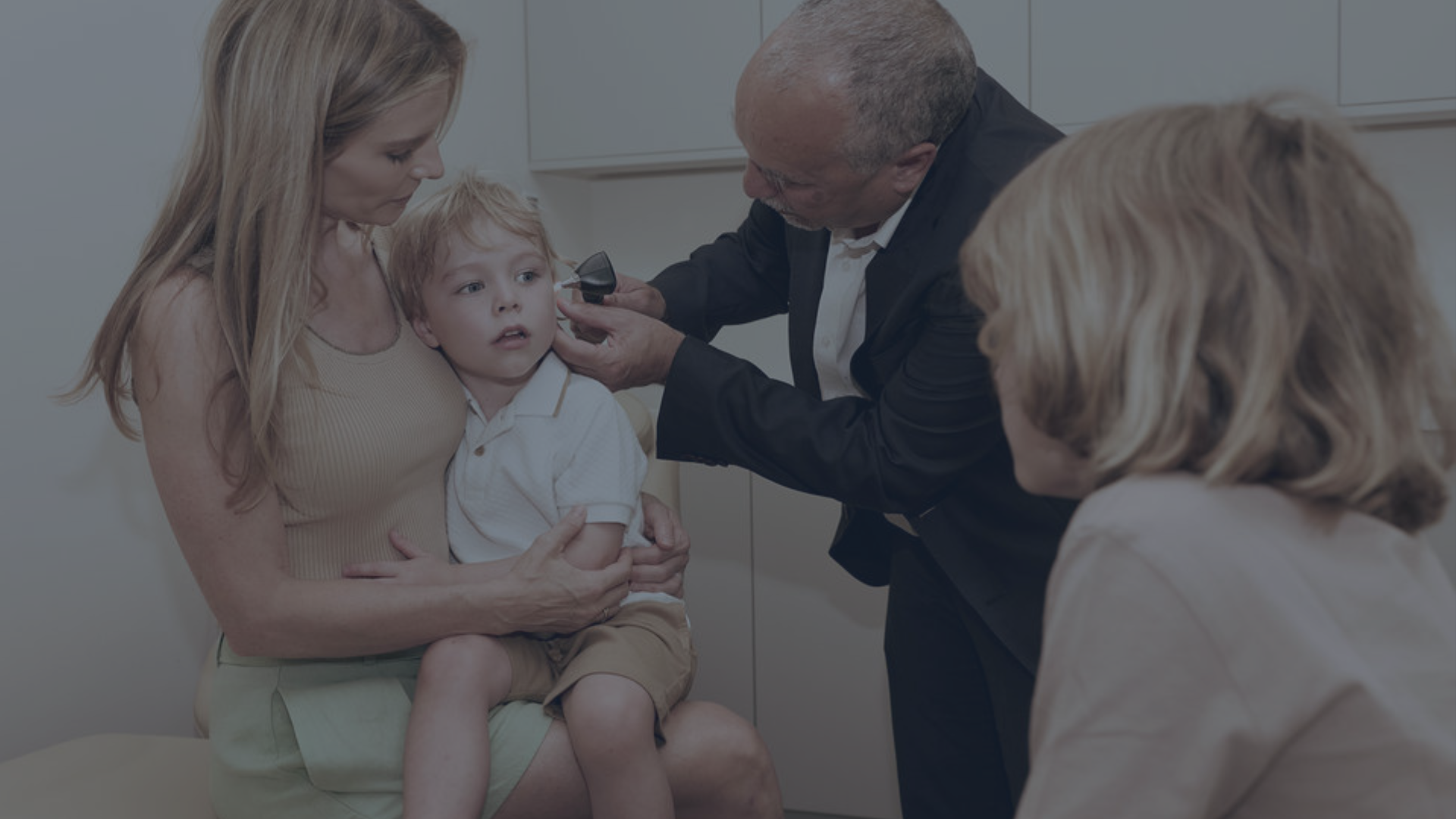 Empty room with pink walls, pink and brown marbled floor, ceiling lights, and an open doorway with glass panels.
