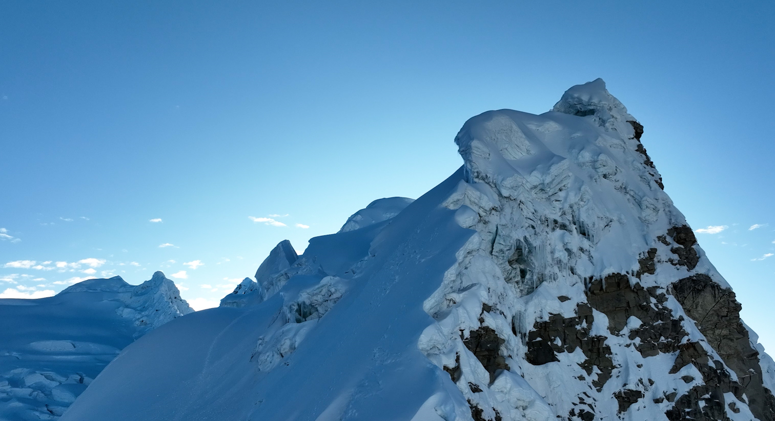 Montaña nevada con picos escarpados y un cielo despejado