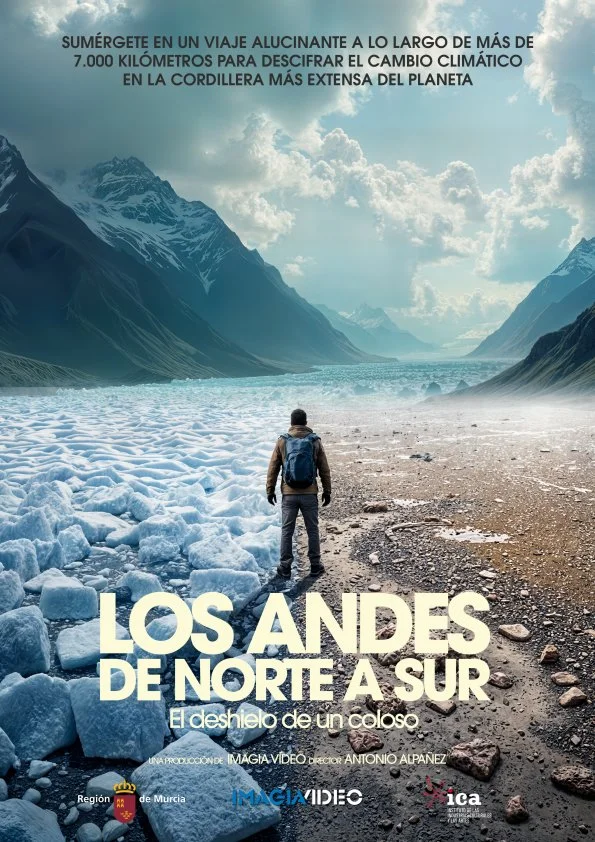 Un hombre con mochila observando los glaciares en la cordillera de Los Andes, con montañas y un cielo parcialmente nublado al fondo.