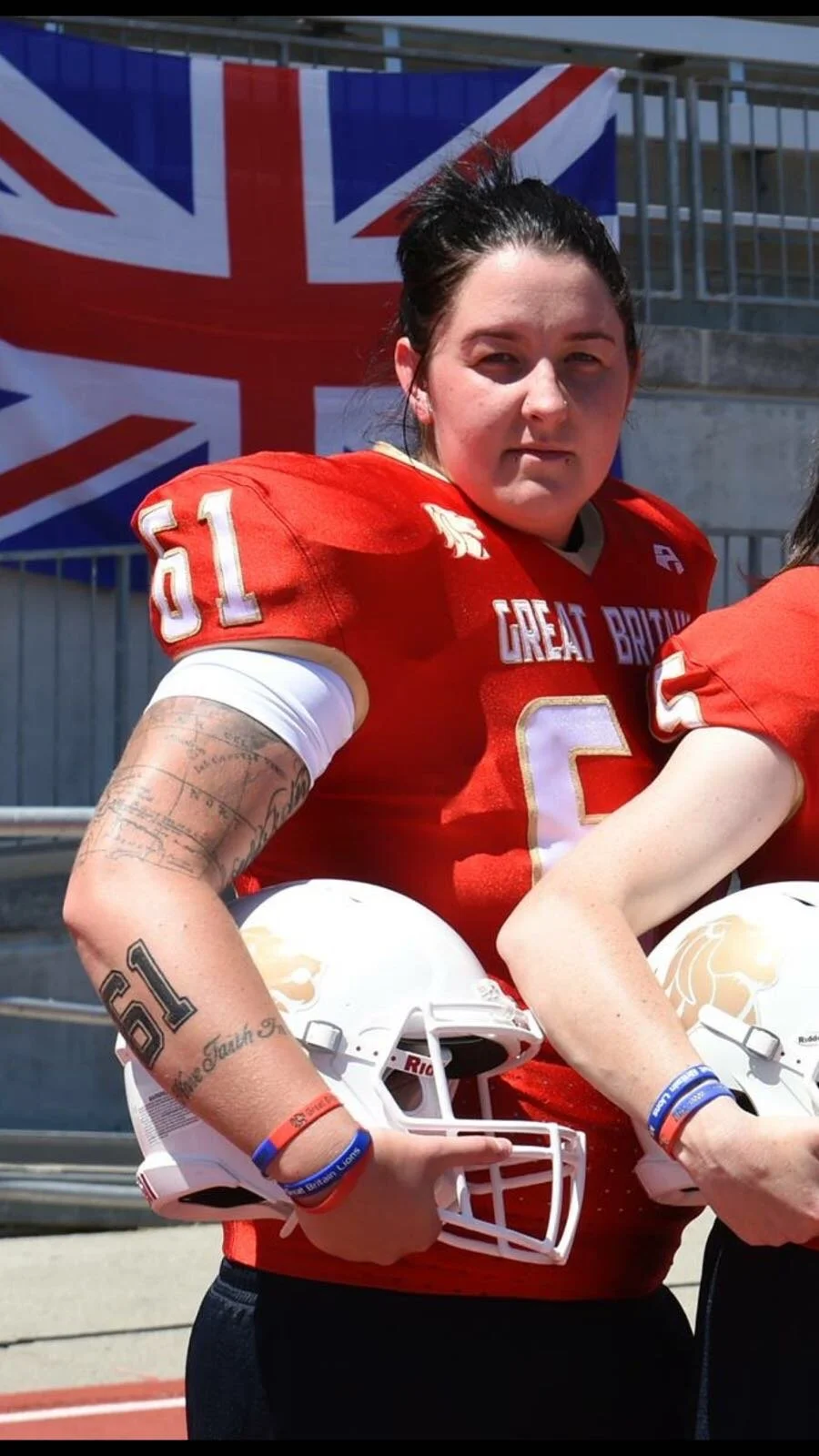 female american football player for great britain holding helmet