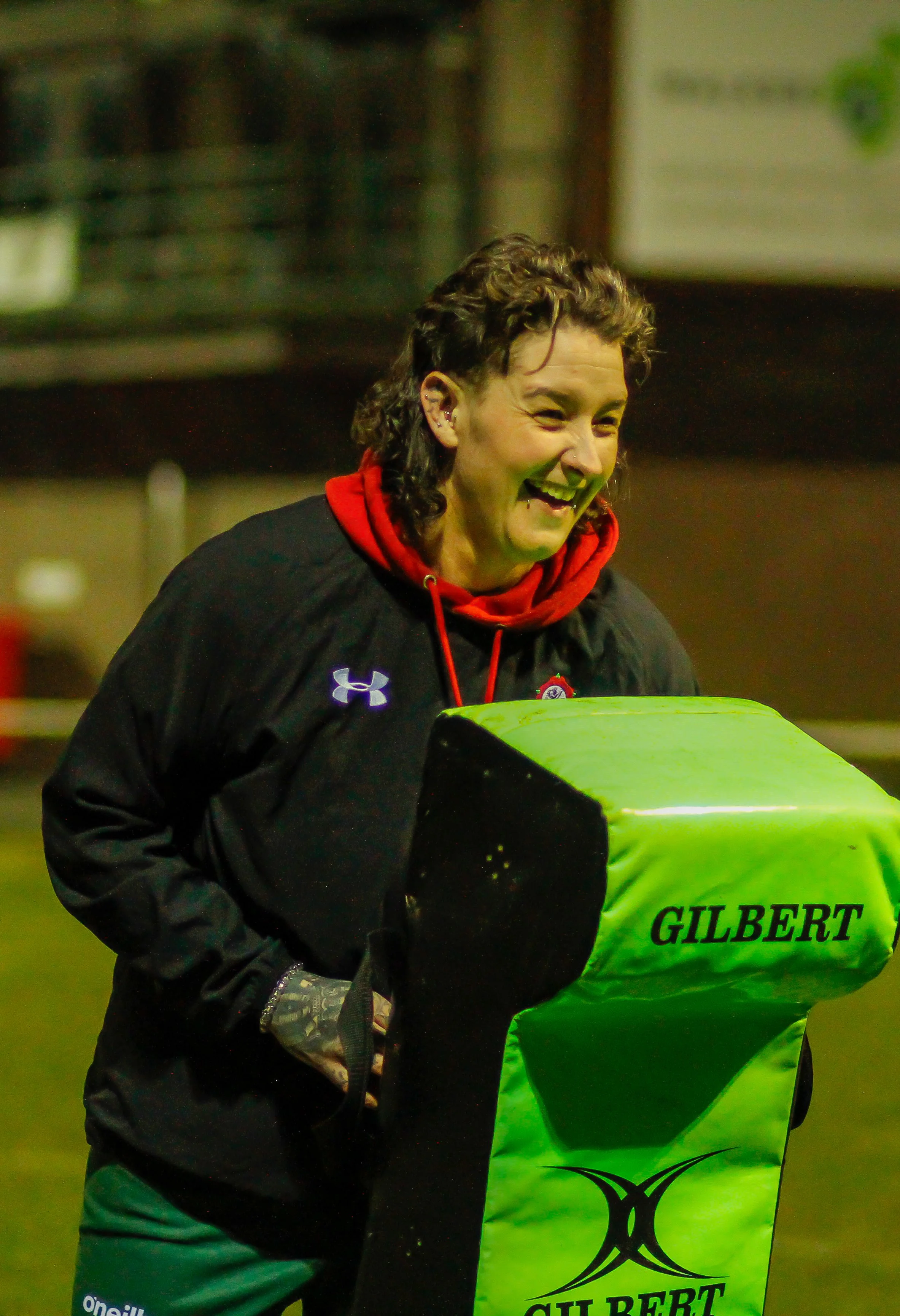 female coach holding a rugby tackle bag for training