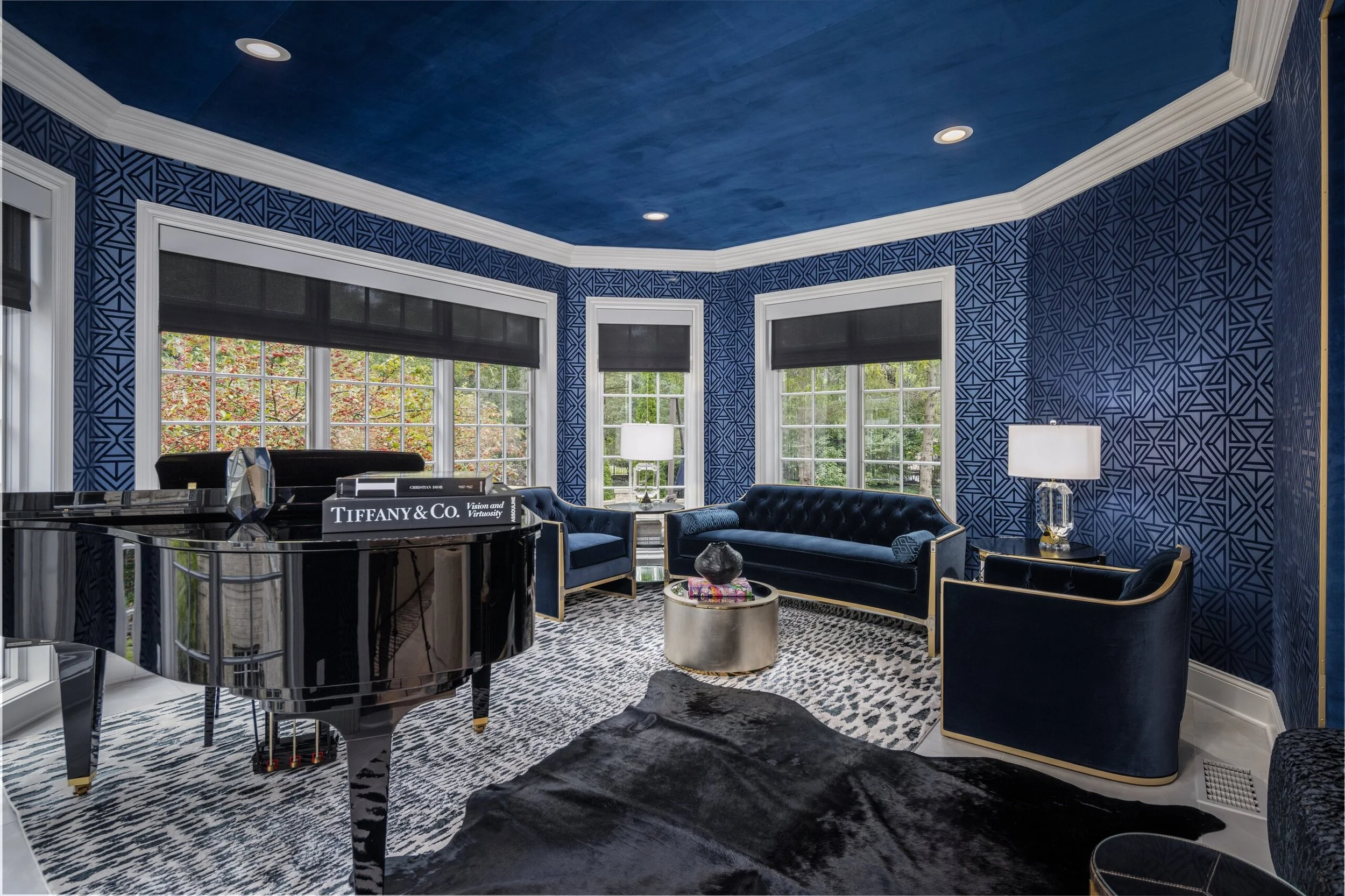 Analog space with a grand piano, navy patterned walls and velvet seating