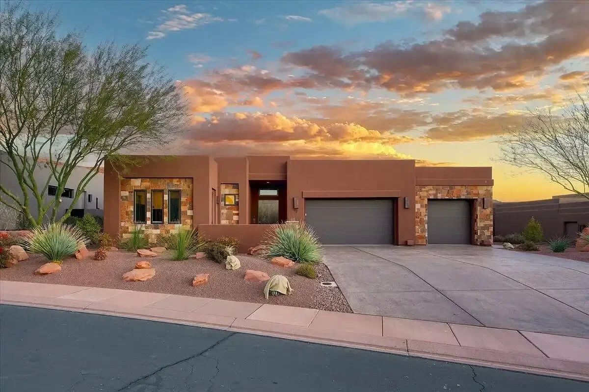 Modern stucco luxury home with desert landscaping and stone accents at sunset, St. George Utah