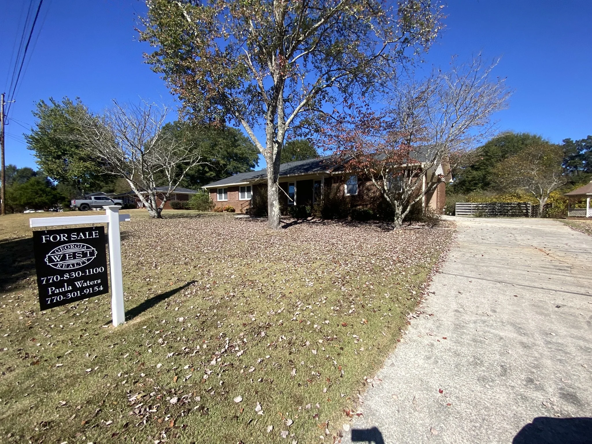 Residential property with leaf-covered lawn requiring seasonal cleanup and exterior maintenance.