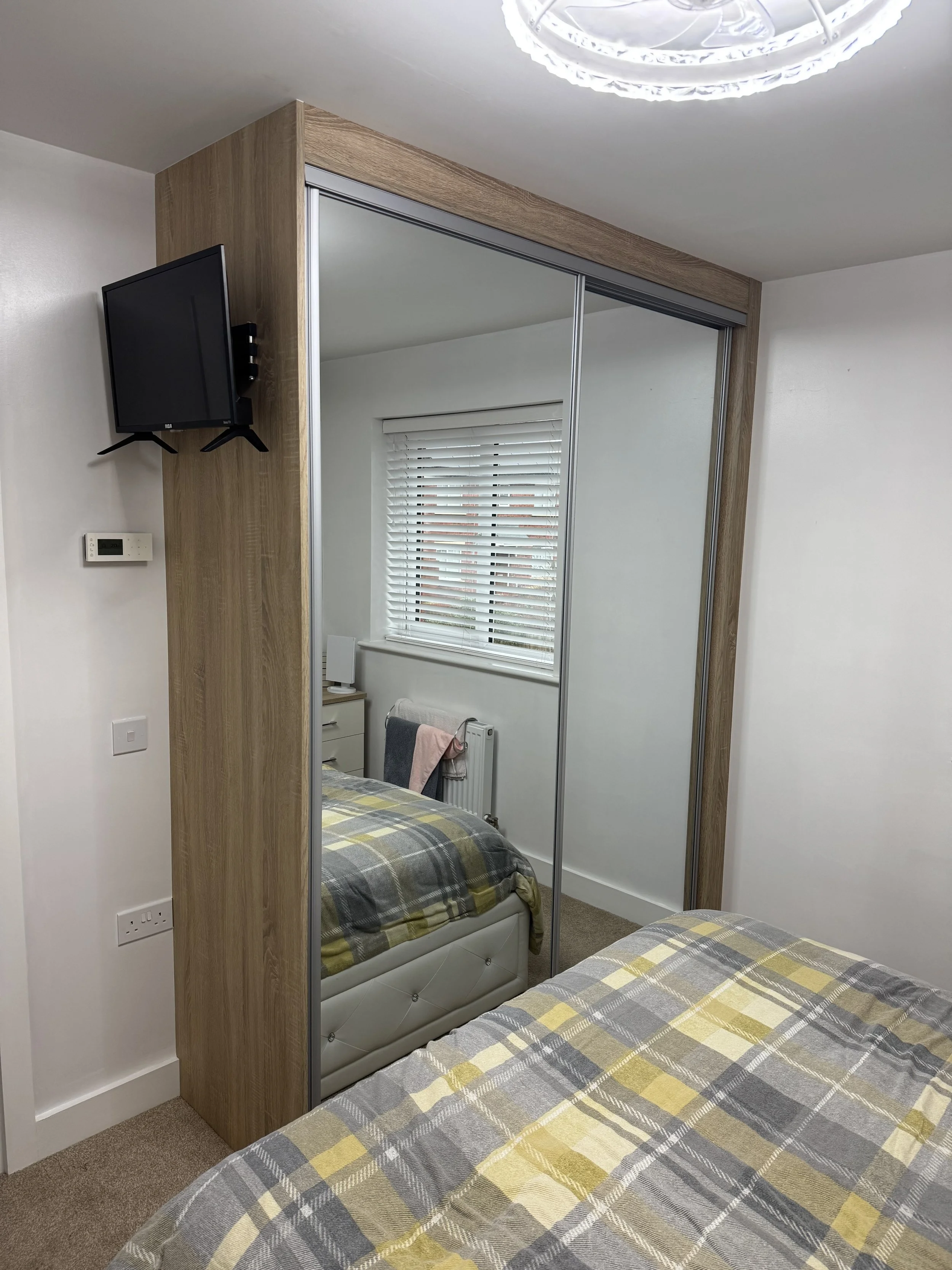 Floor to ceiling fitted sliding wardrobe with tall mirror doors
