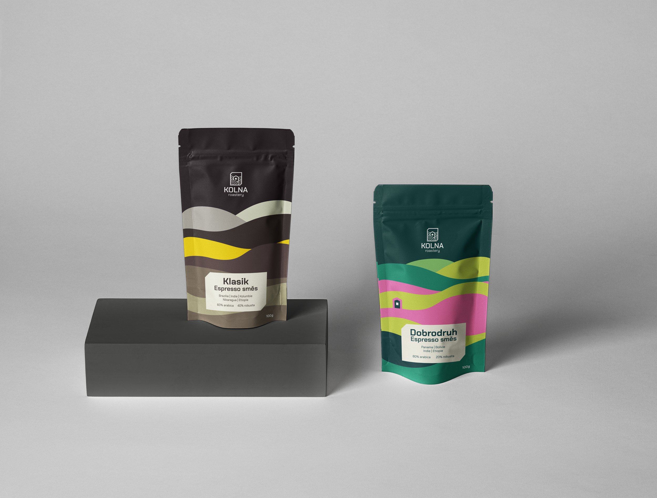 Moderní design obalů na výběrovou kávu Kolna. Sáčky s abstraktním barevným vzorem připomínajícím krajinu a vrstevnice.