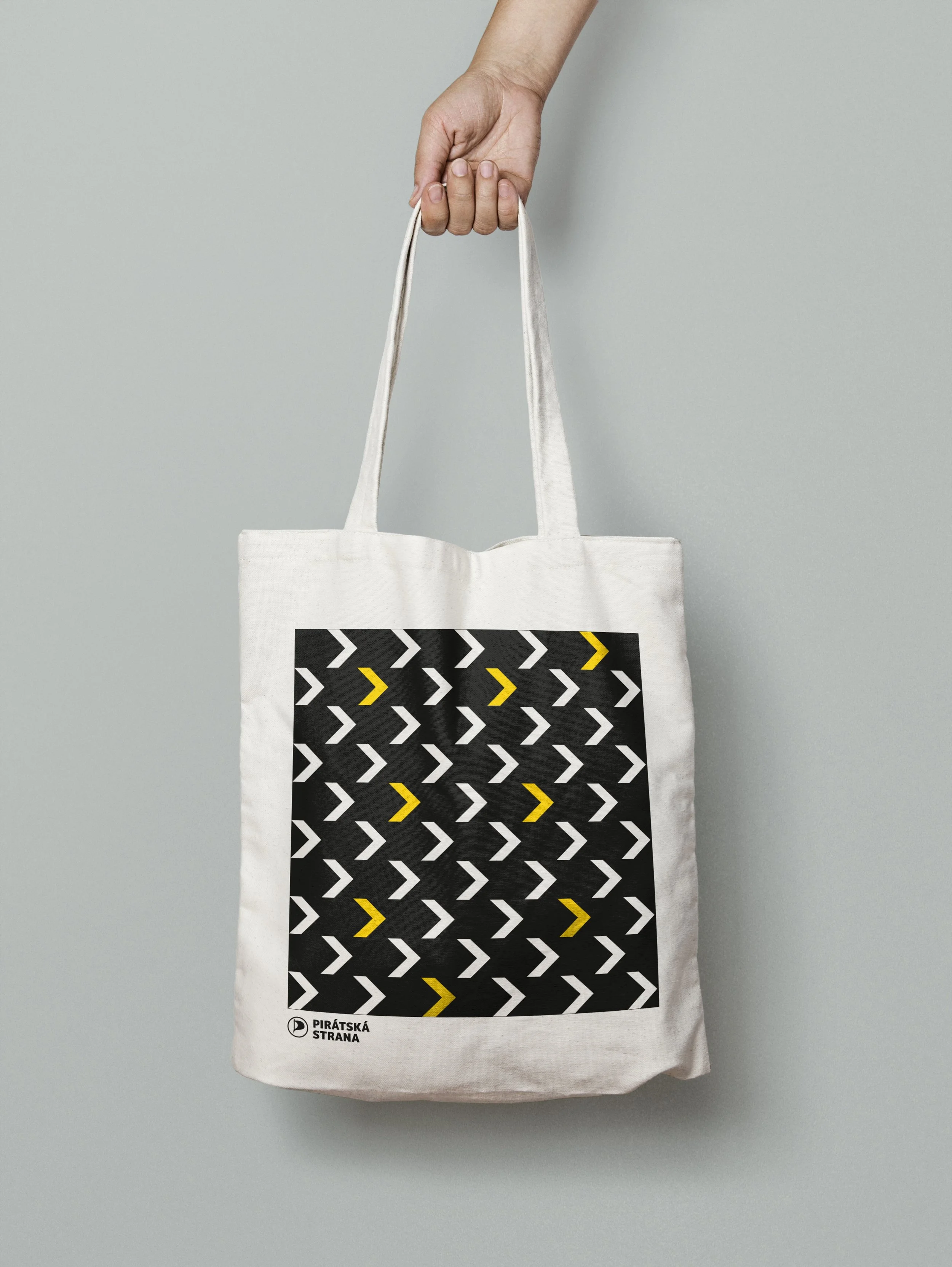 Volební merch a propagační předměty. Bílá plátěná taška a tričko s minimalistickým vzorem šipek. Ukázka aplikace brandingu na textil a vizitky.