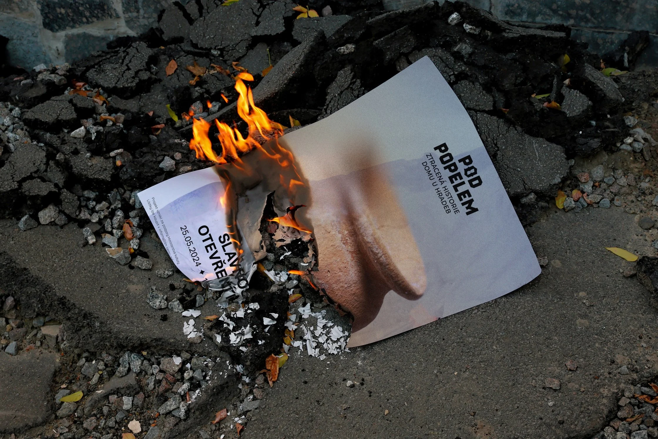 Vizuální identita expozice Pod popelem v Novém Jičíně, grafický design Miloš Frič. Hlavní motiv gotického písmene O s ukrytým symbolem husitského kalicha vystupujícího z popela.