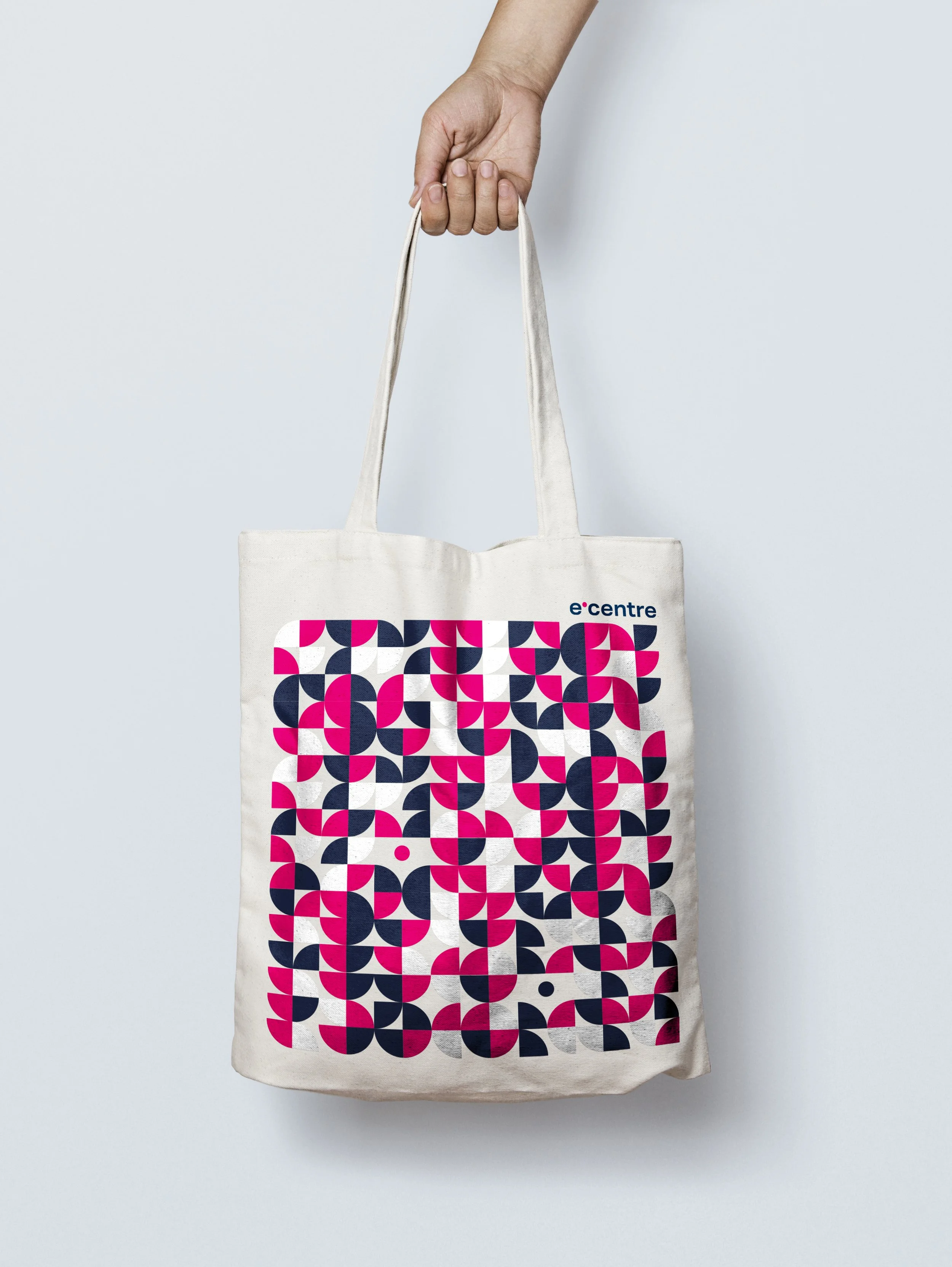 Plátěné tašky s potiskem firemního vzoru e-centre. Design reklamních předmětů (merch) využívající fragmenty loga a výraznou magentovou barvu.