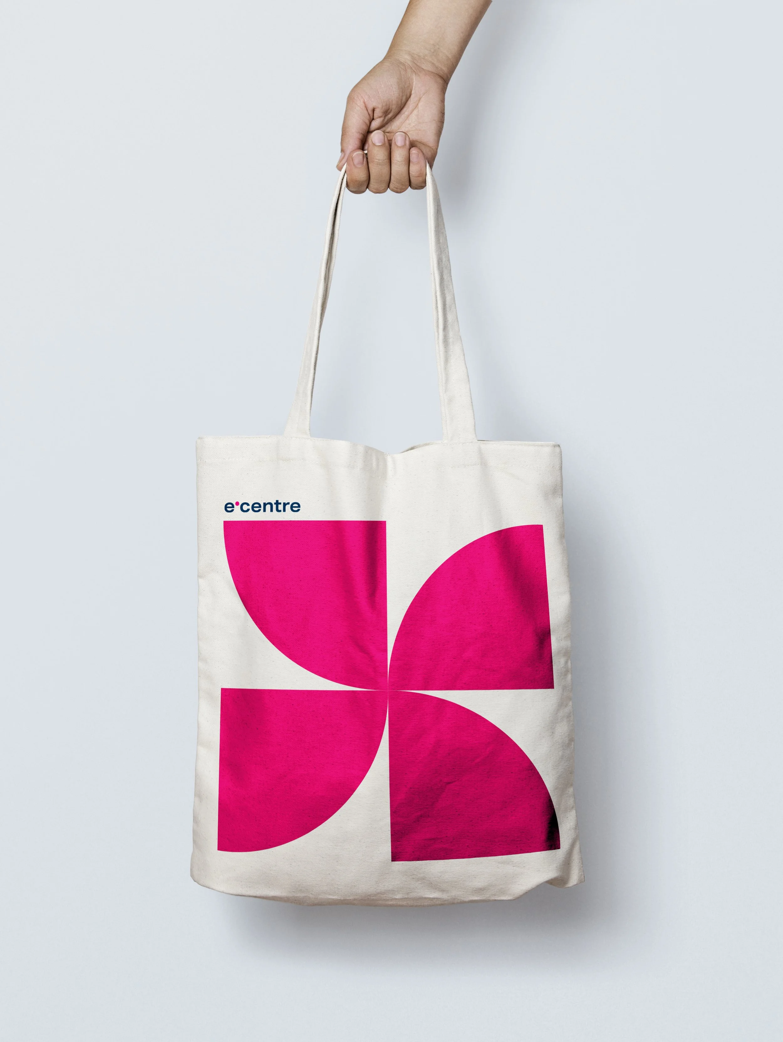Plátěné tašky s potiskem firemního vzoru e-centre. Design reklamních předmětů (merch) využívající fragmenty loga a výraznou magentovou barvu.