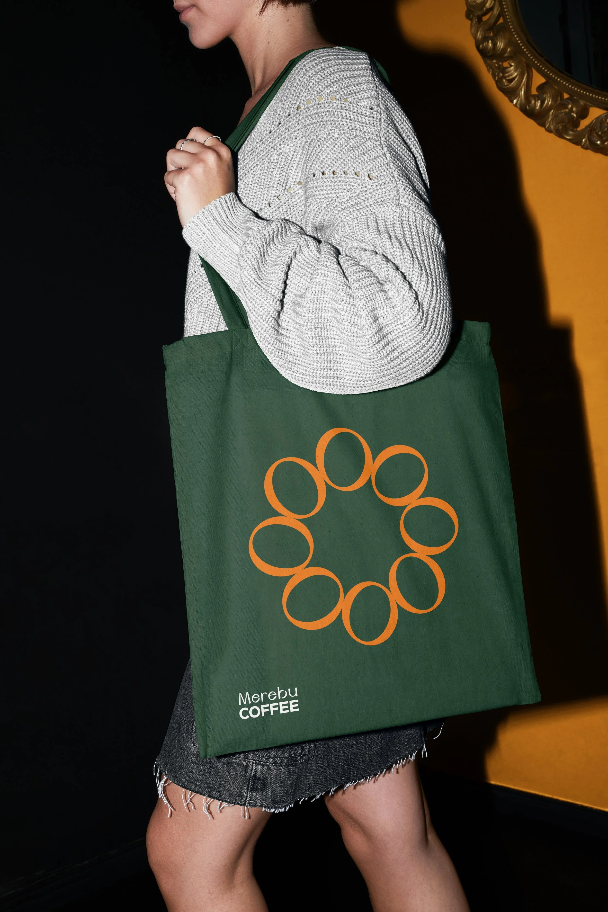 Zelená plátěná taška (tote bag) s oranžovým logem Merebu. Design firemního merche a doplňků pro milovníky kávy.