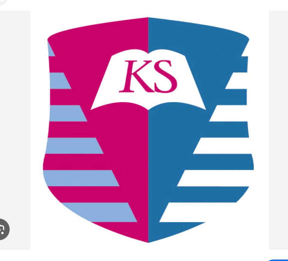 A shield-shaped logo split vertically into pink and blue halves with chevron stripes on each side. In the center, an open book with the letters 'KS' in pink inside. The pink and blue colors alternate across the design.