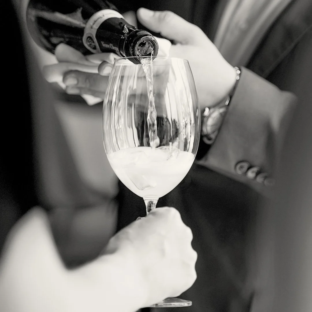 Person pouring champagne into a wine glass