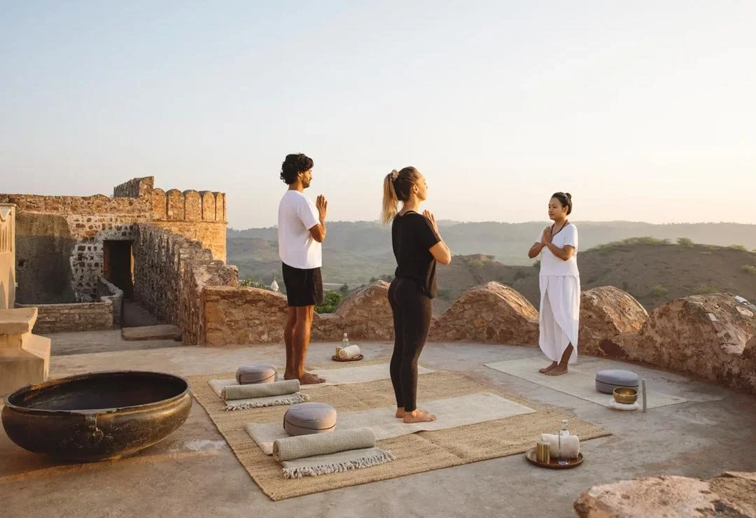 Two hotel guests enjoy a wellness session in the morning sunshine.