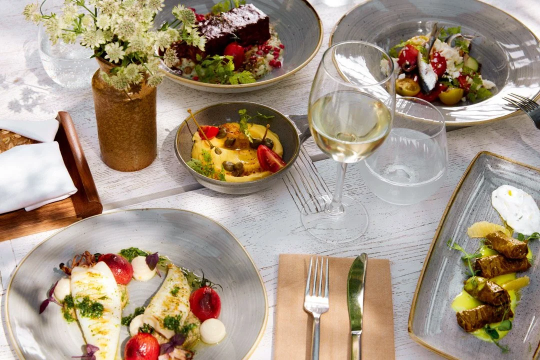 A table set with delicious mediterranean food and wine to showcase the Ikos resorts Supper Club at Agent Nouveau.