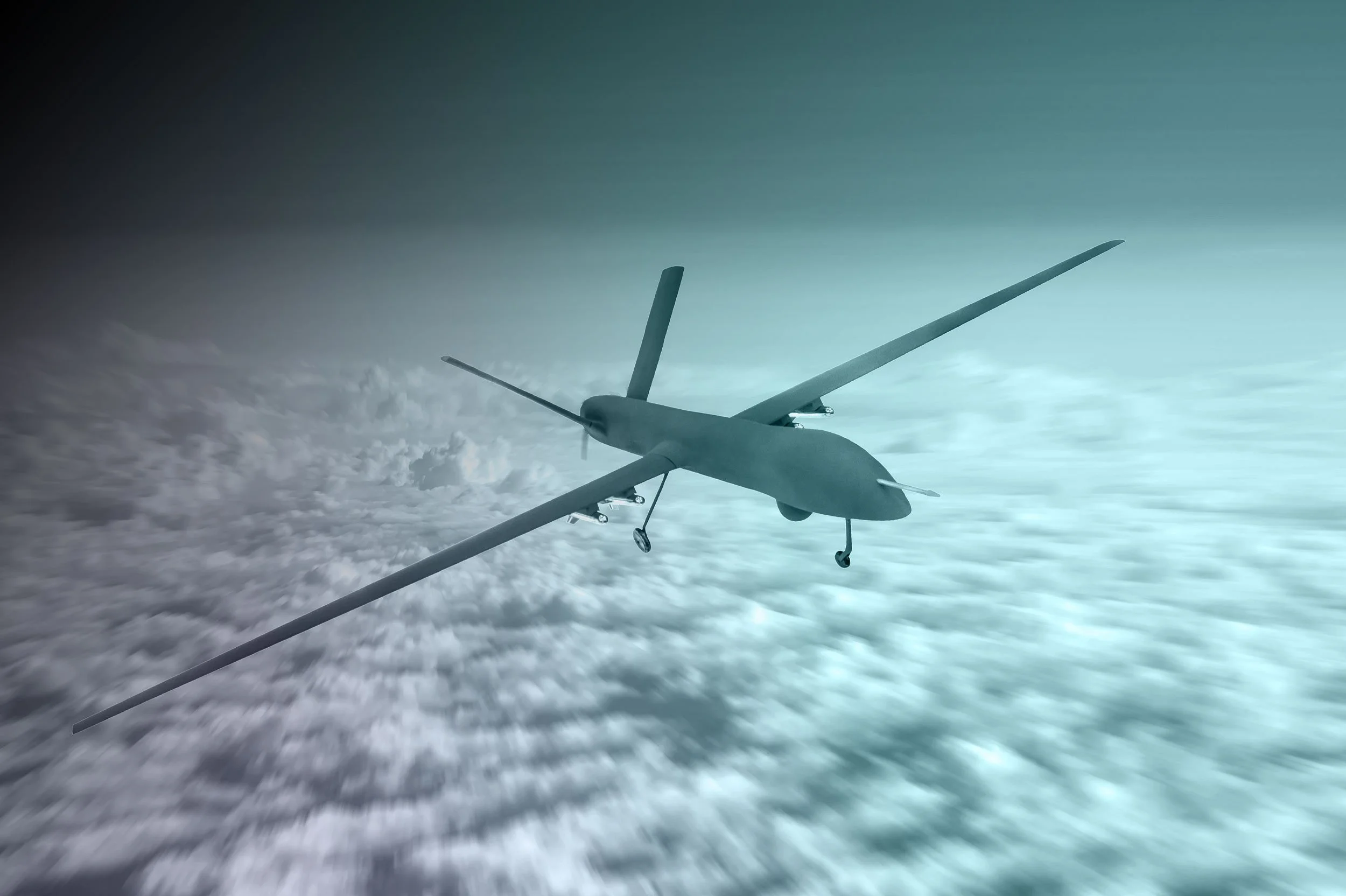 Unmanned drone flying above the clouds in the sky.