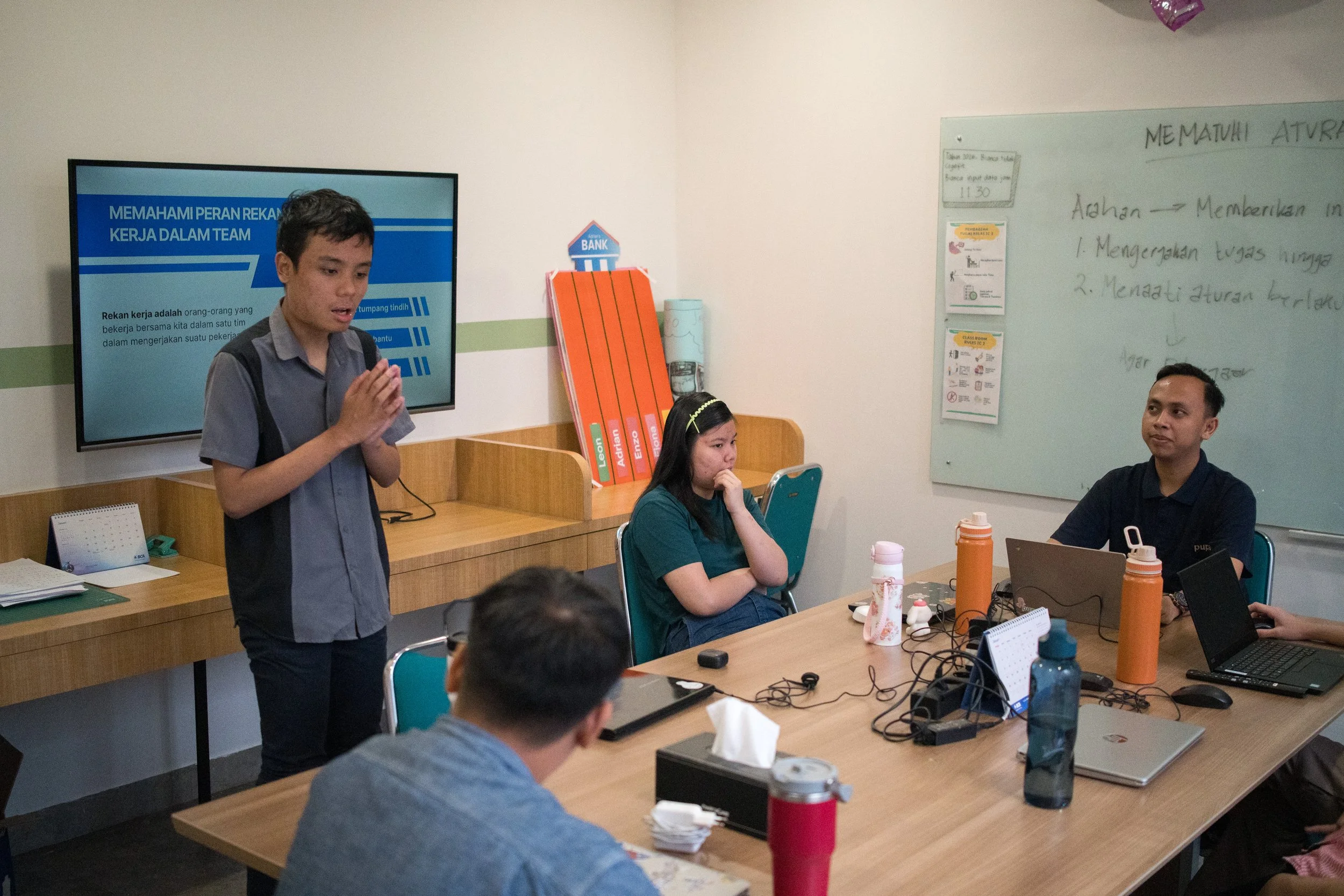 Neurodivergent young adults participating in a PUPA Center learning session, presenting ideas and collaborating in a supportive classroom environment focused on inclusive education and skills development.