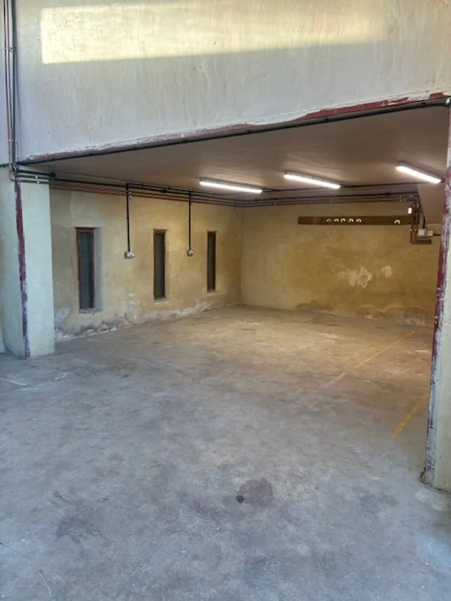 Empty underground parking garage with concrete floors and walls, small vertical windows, and fluorescent lighting.Resin floors The Wye Valley, Herefordshire, South Wales, West Midlands, west, cardiff, birmingham, bristol
