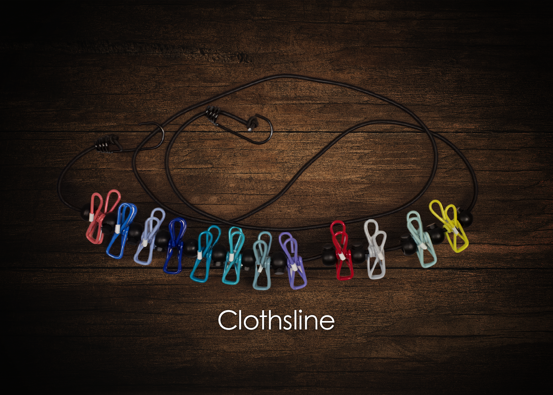 Colorful clothespins clipped onto black elastic cords on a wooden surface, with the word 'Clothsline' written below.