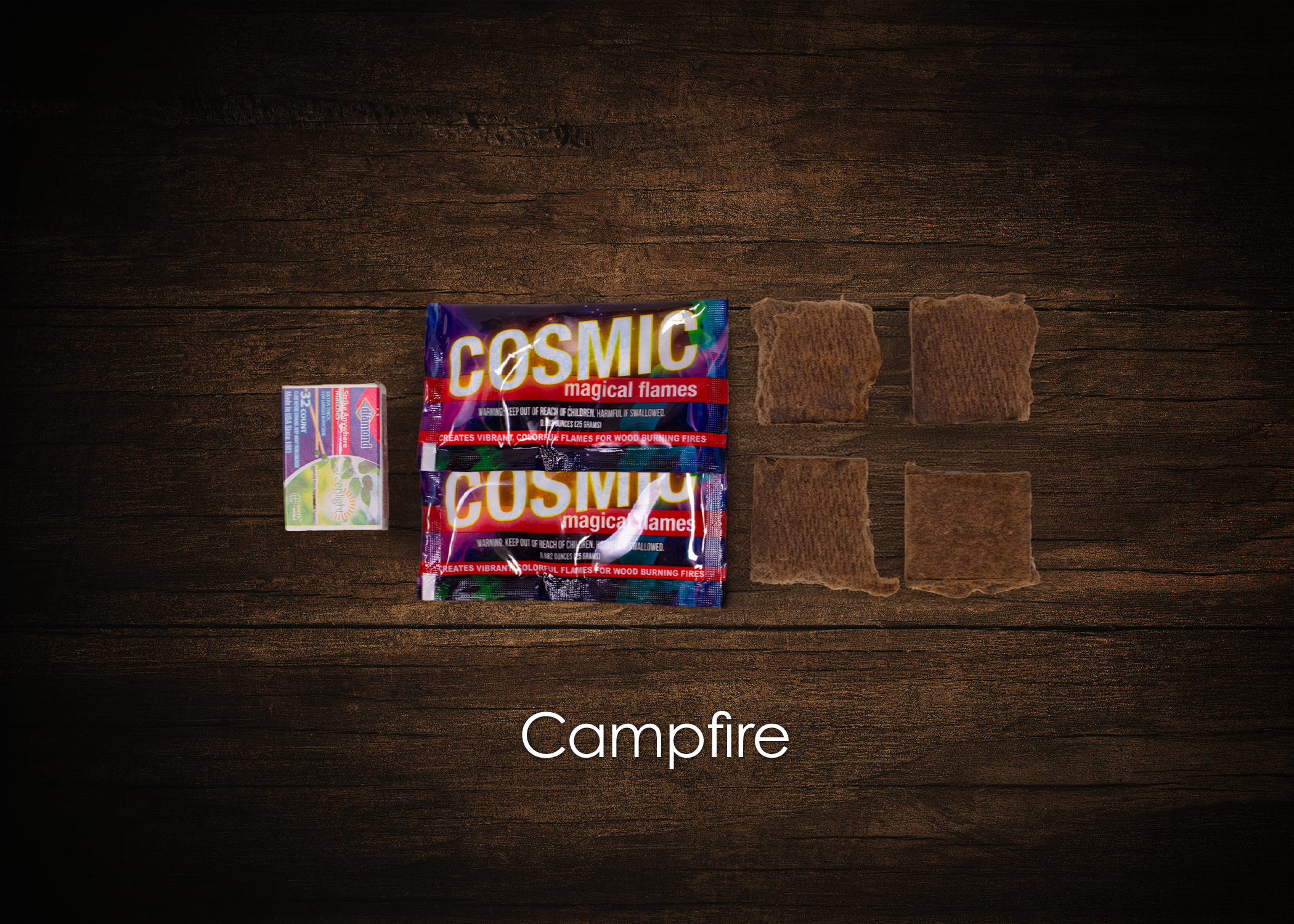 Box of matches, two packages labeled 'Cosmic', two brown rocks or pieces of wood, and four pieces of brown material on a wooden surface, with the word 'Campfire' at the bottom.