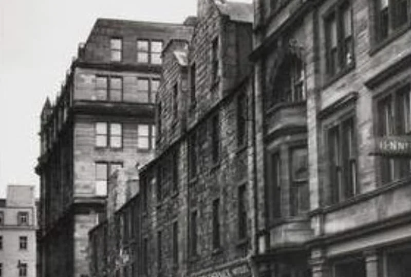 Black and white photo of the 19005 Extension of The Jenner Building with multiple stories, some with rounded balconies and large windows, in a city street.