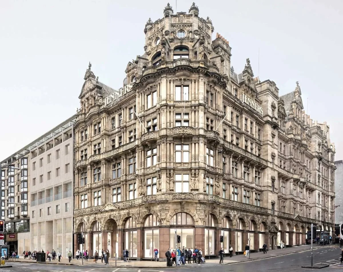 A historic multi-story building with ornate architectural details, located on a busy city street corner with pedestrians and traffic visible.